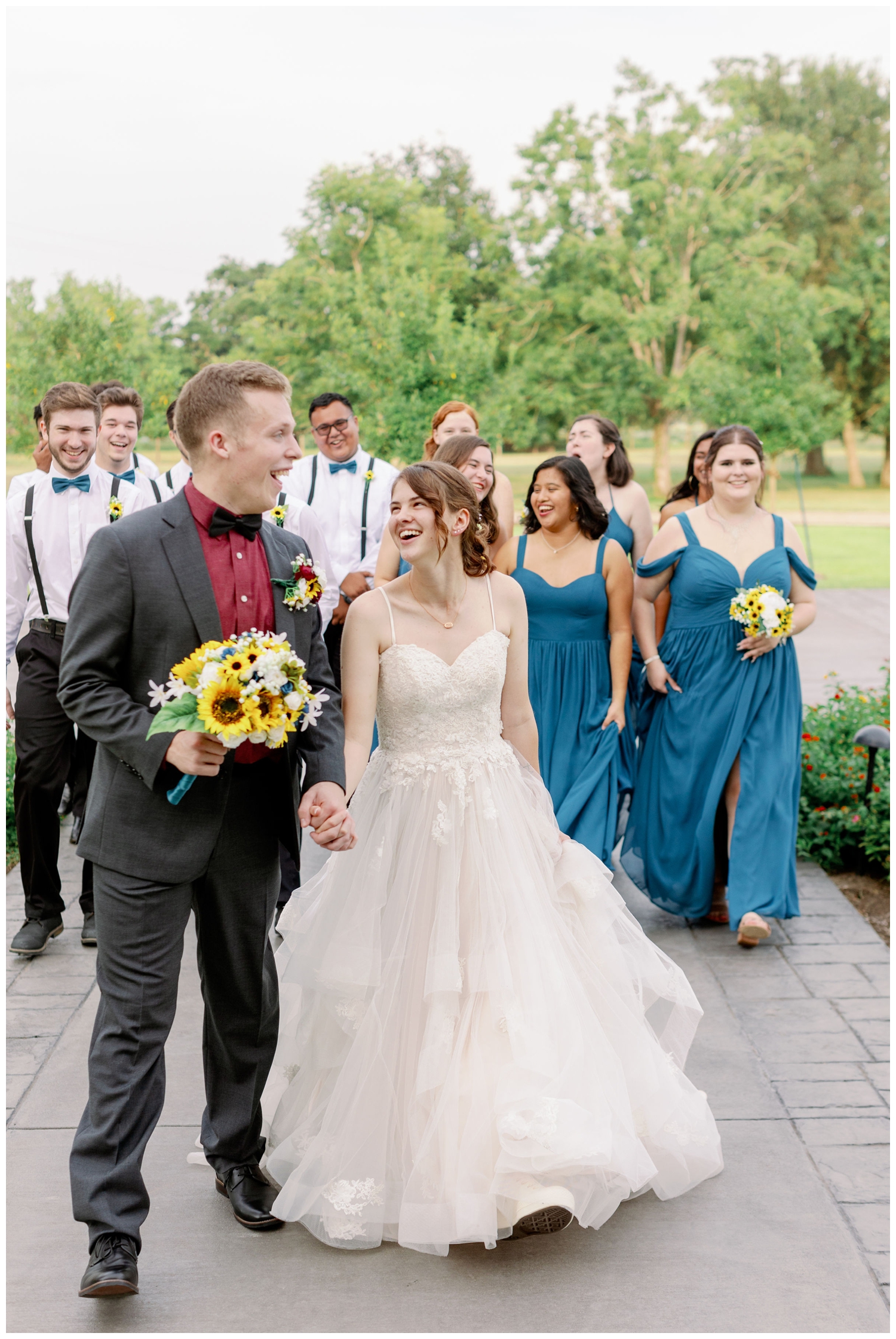 bride and groom holding hands and walking with wedding party for The Oaks at the Oak Plantation wedding