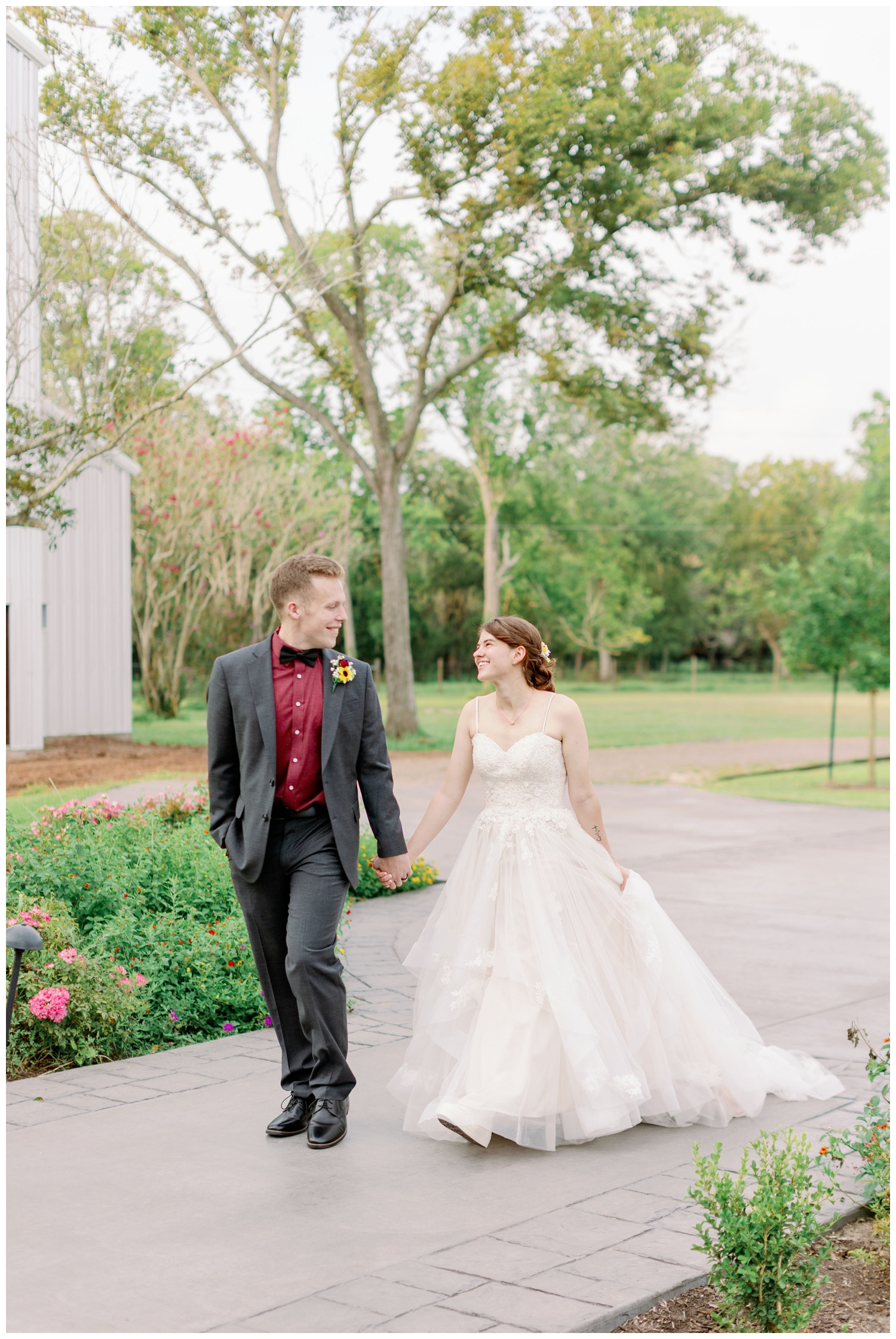 bride and groom holding hands and walking on path at The Oaks at the Oak Plantation wedding