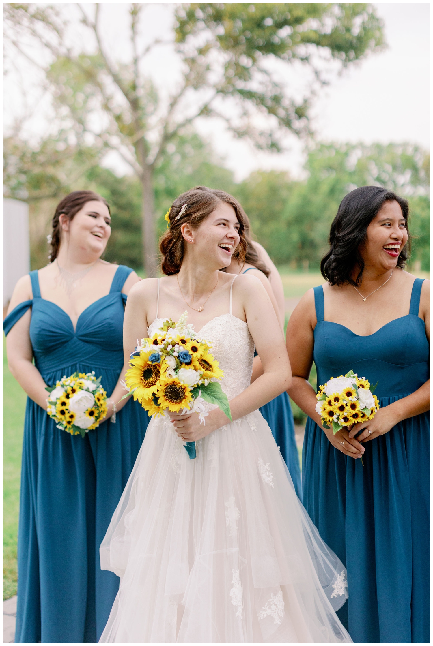 bride and bridesmaids laughing and holding sunflower bouquets