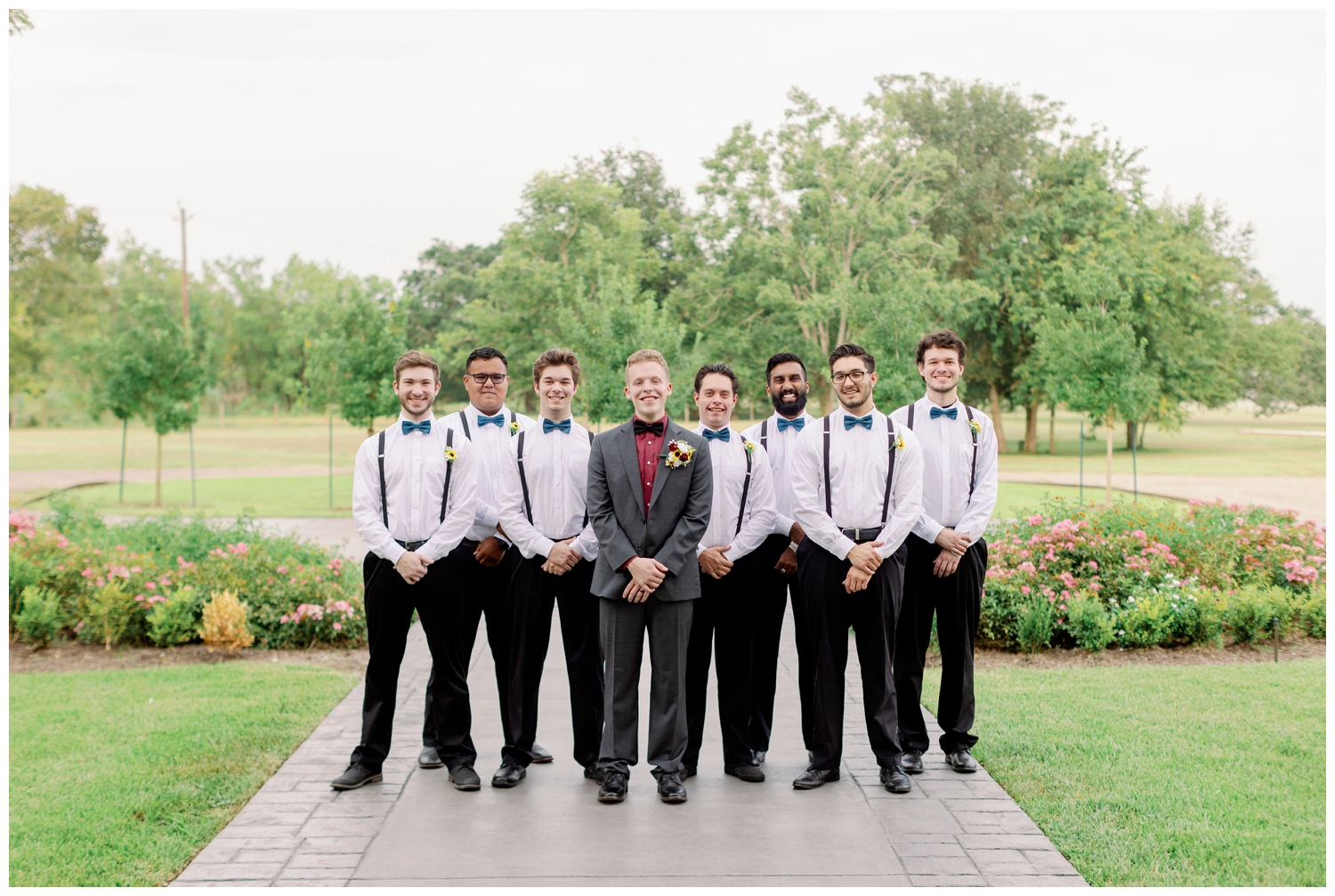 groom standing with groomsmen in white shirts and suspenders for The Oaks at the Oak Plantation wedding