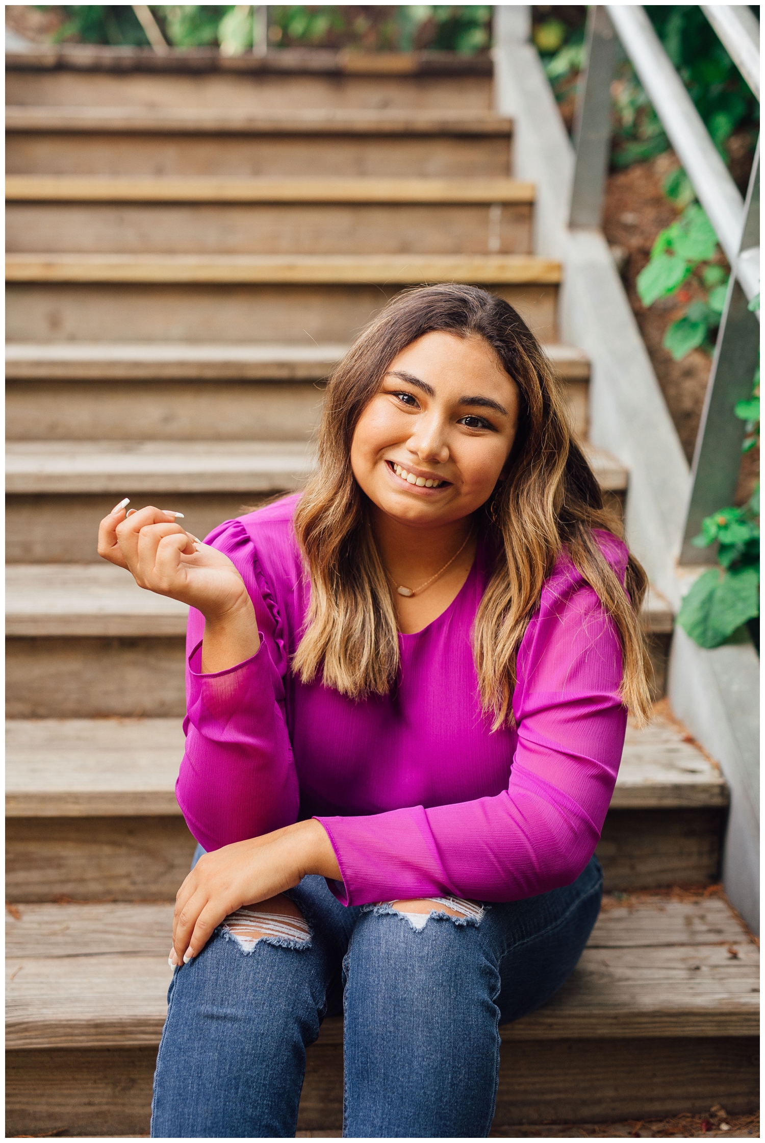 best friends senior session portrait with girl in jeans sitting on staircase at Buffalo Bayou
