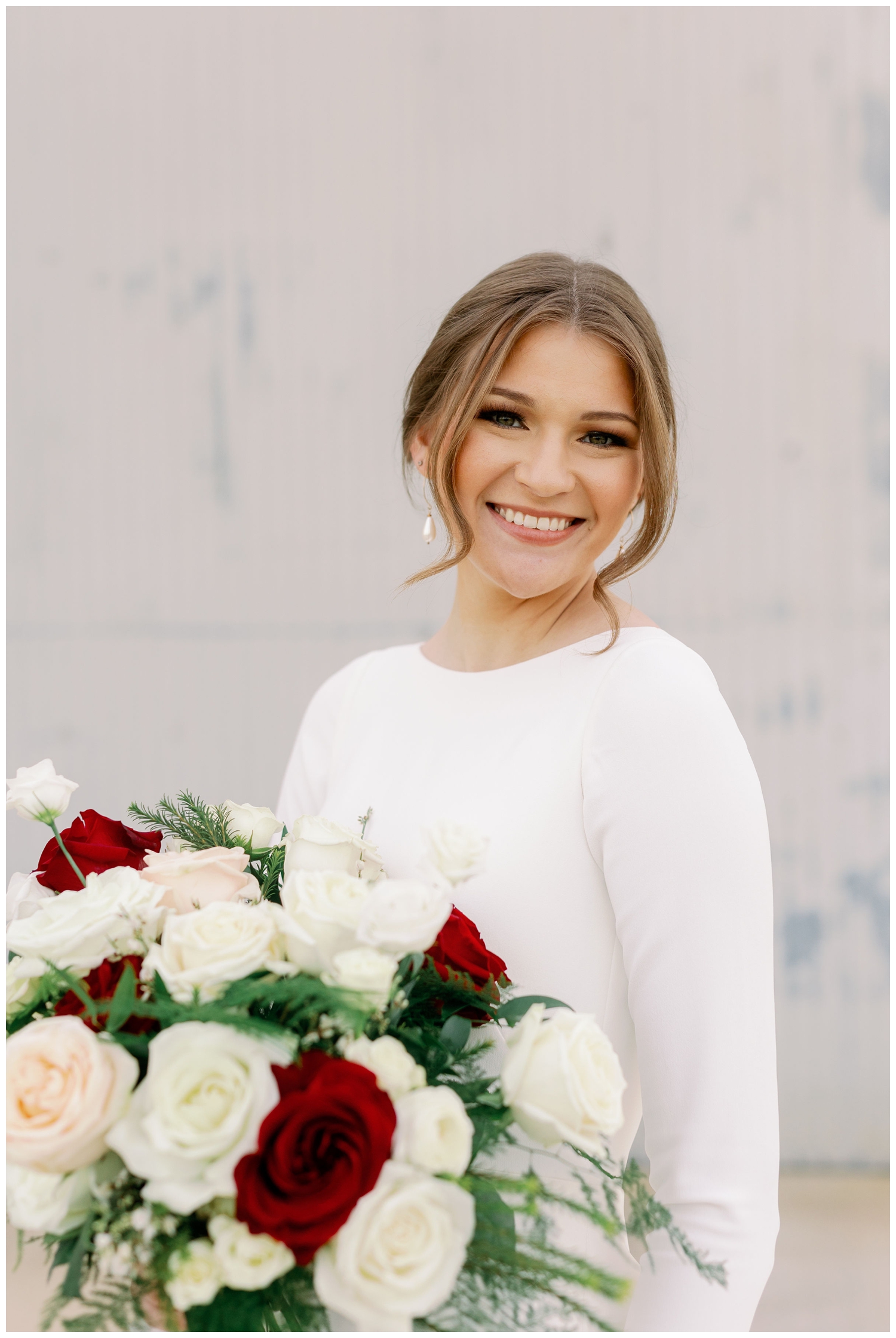 College Station Bridal Portraits with bride smiling at camera holding white burgundy bouquet