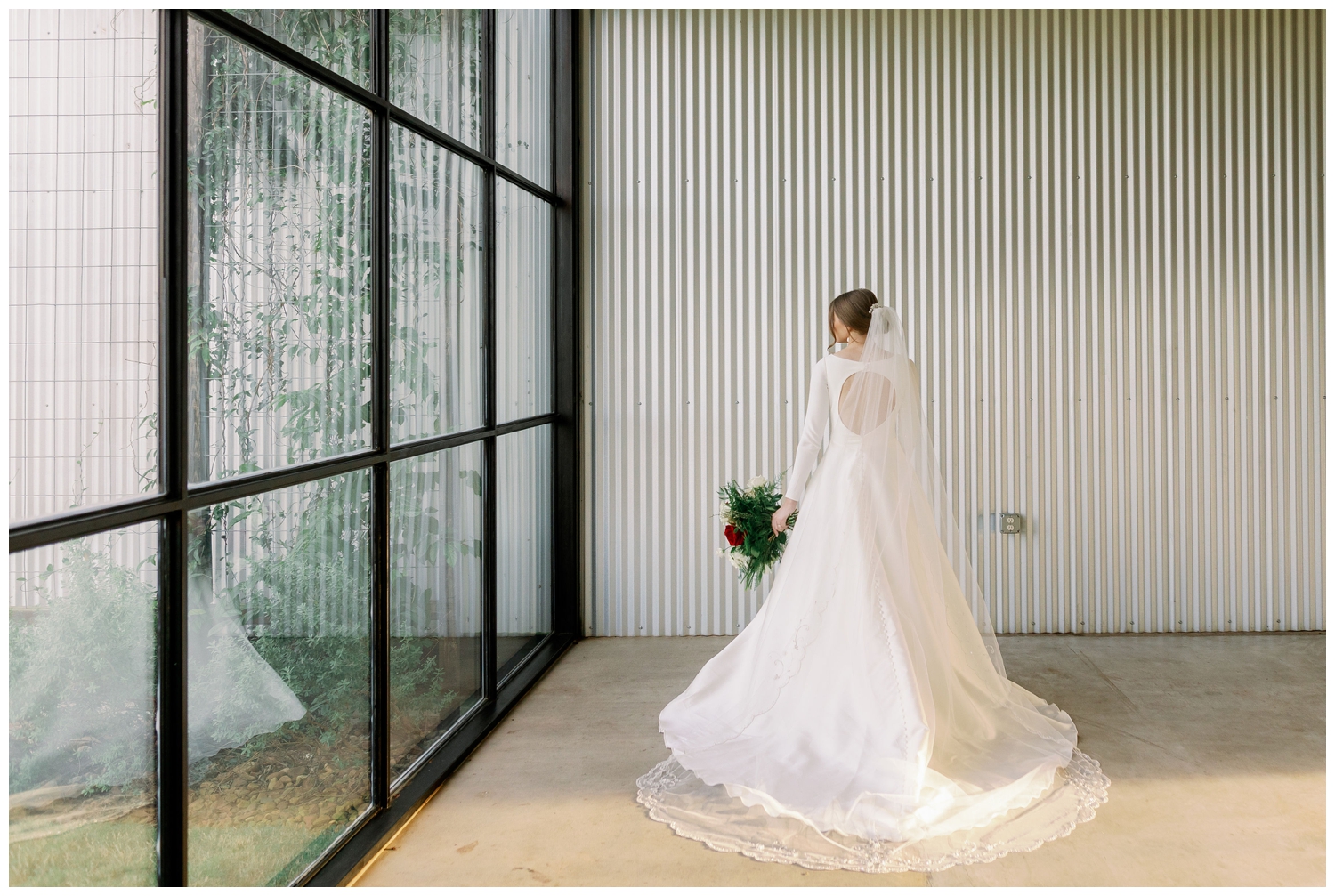 back of wedding gown with bride standing by window
