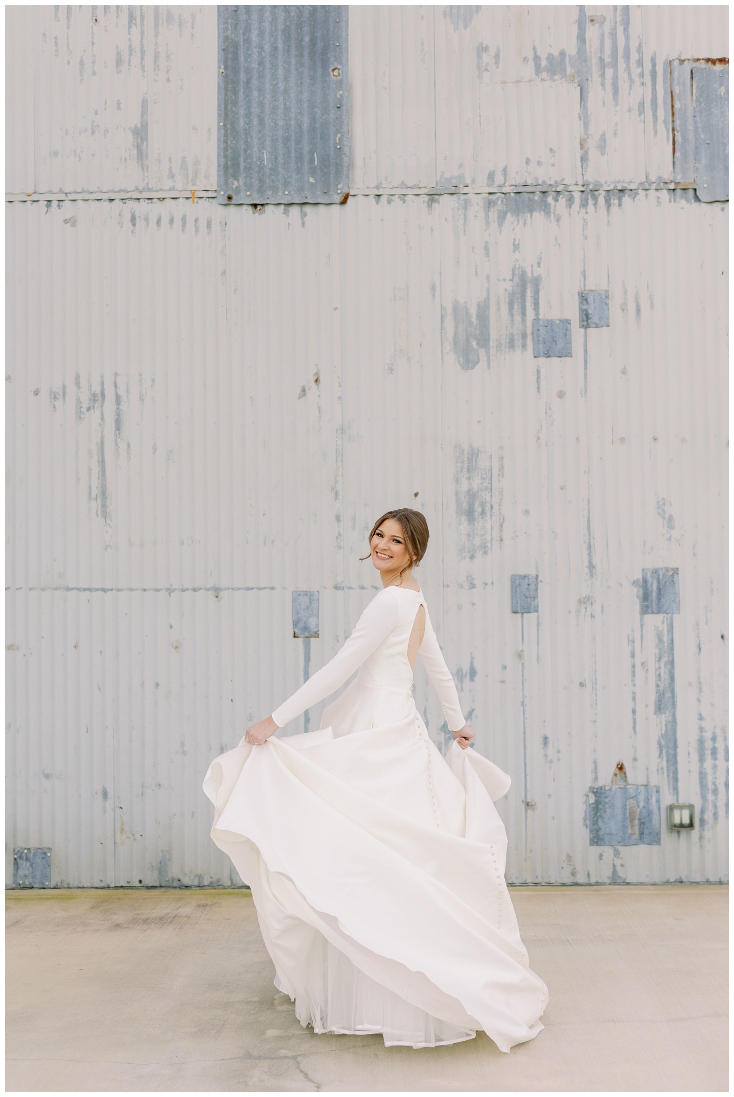 bride in long sleeved wedding gown twirling her dress during College Station Bridal Portraits