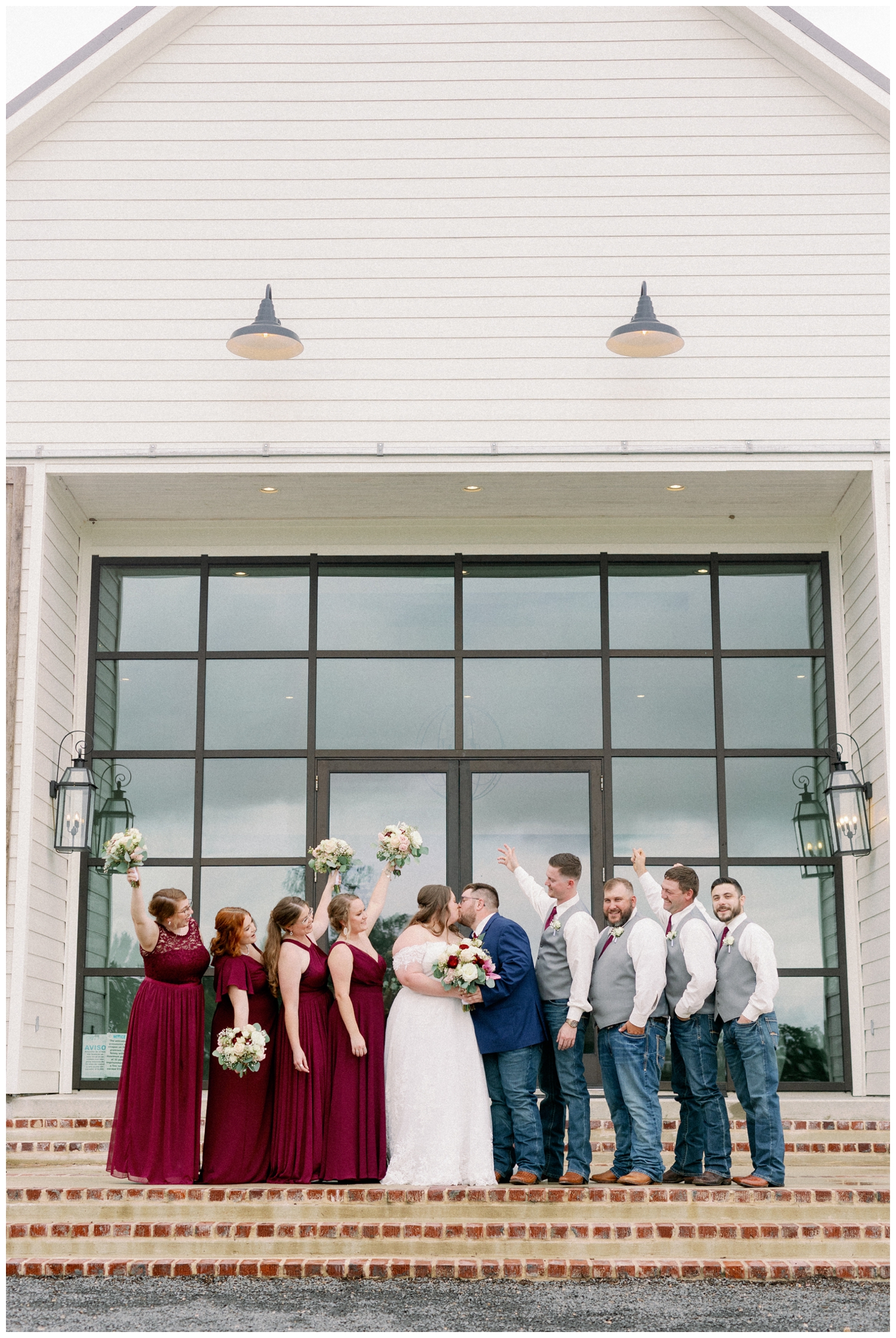 full bridal party celebrating bride and groom kissing for College Station wedding photographer