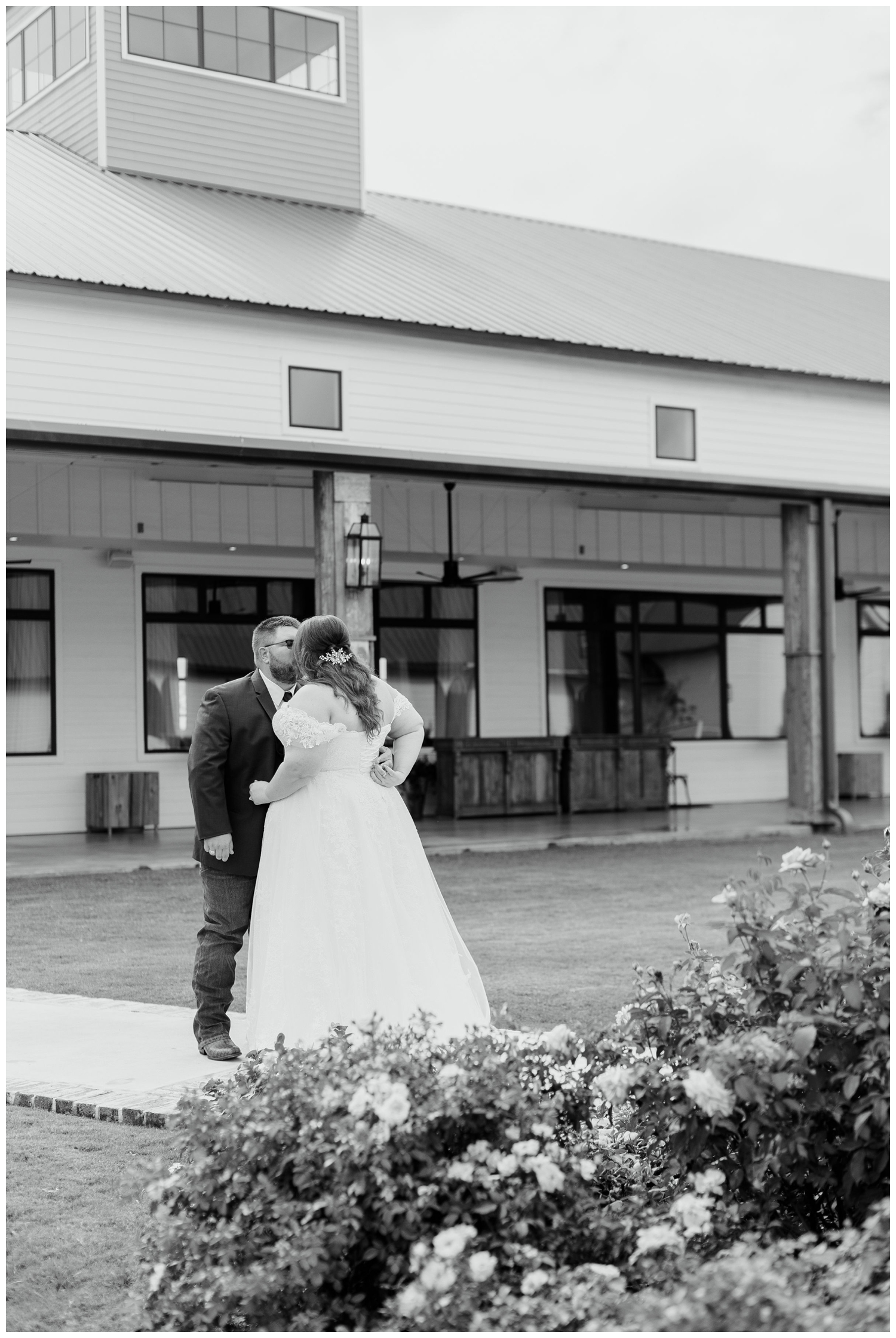 black and white portrait of bride and groom kissing College Station wedding photographer during first look