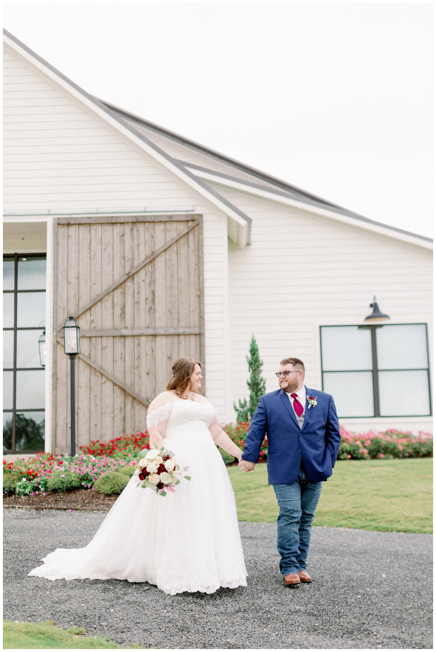bride and groom holding hands walking outside Deep in the Heart Farms wedding venue in College Station