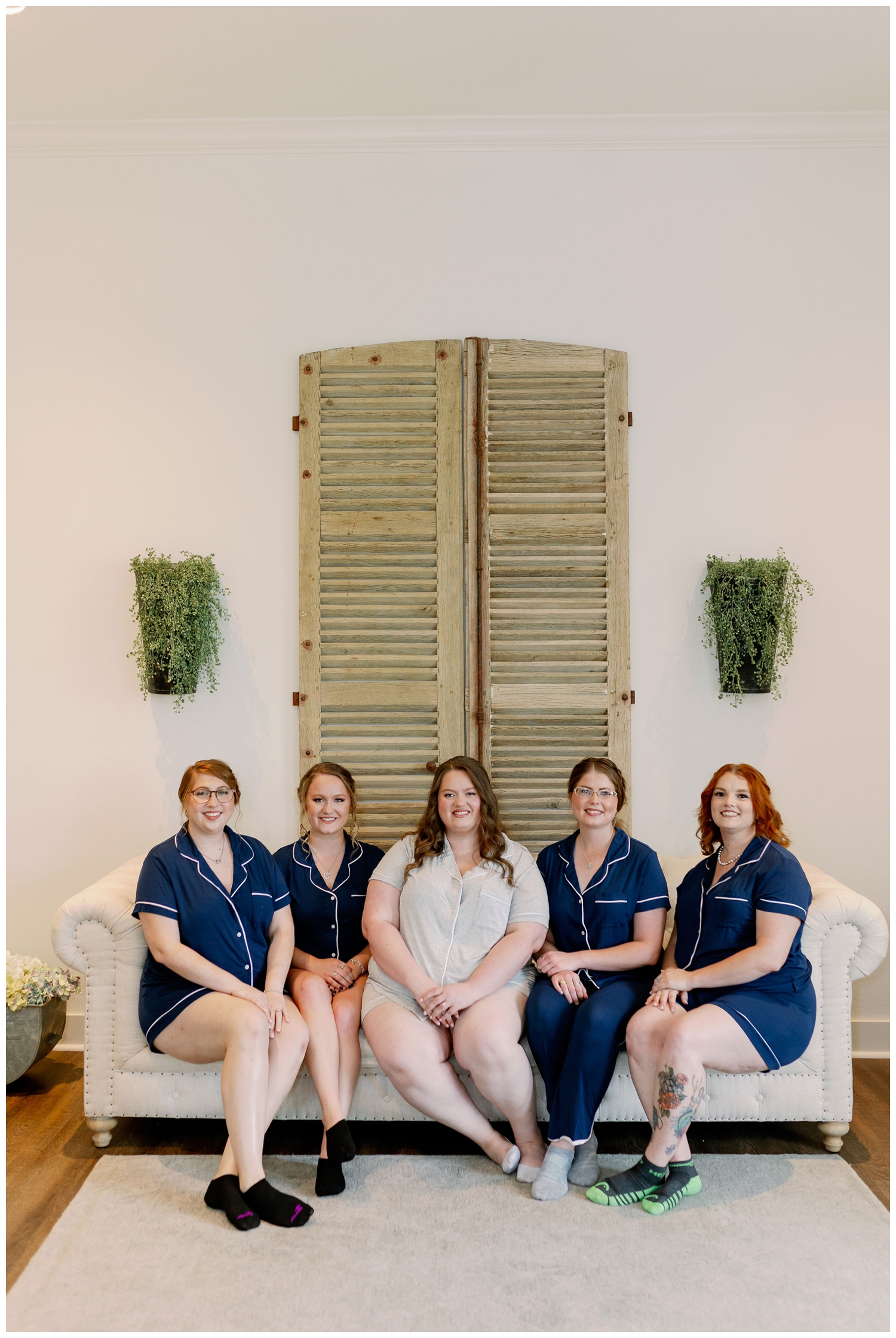 bride and bridesmaids in matching navy pajamas inside Deep in the Heart Farms bridal suite