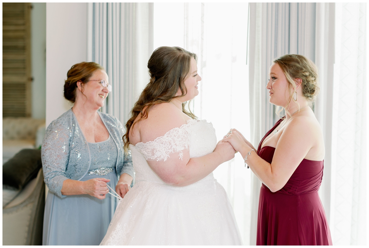 bride getting ready photo with mother of bride and bridesmaid in maroon dress