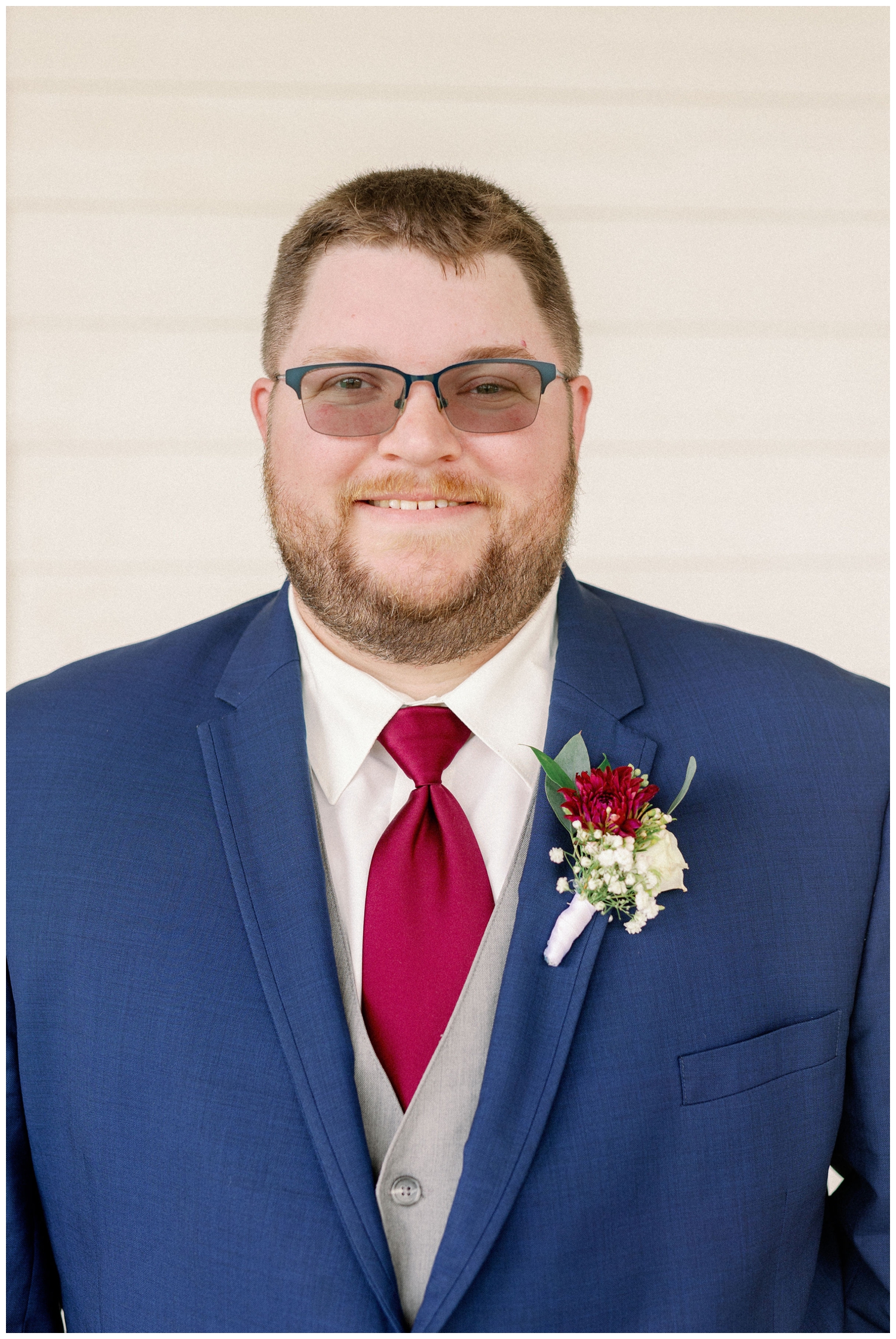 groom in blue jacket and gray vest smiling for College Station wedding photographer