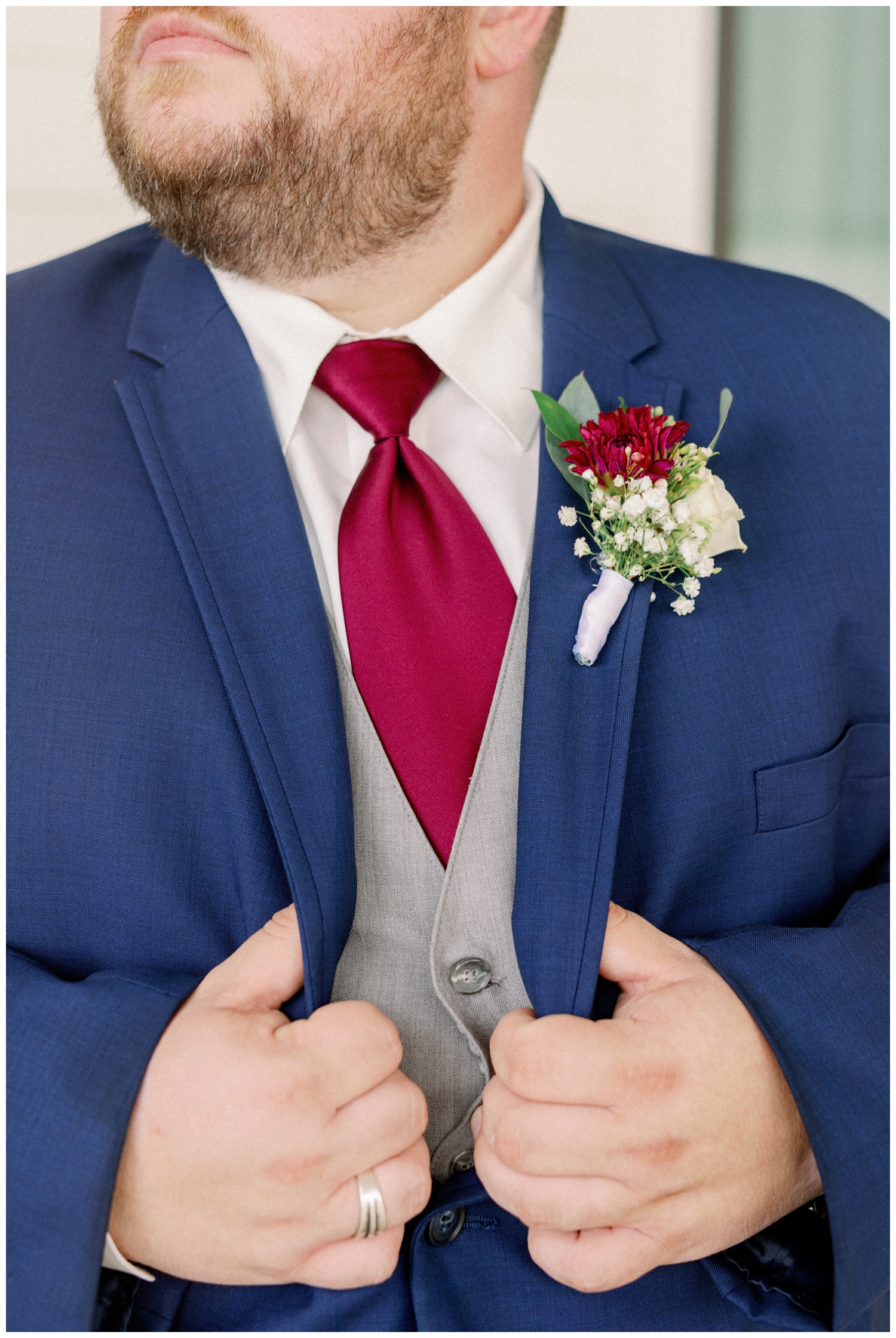 detail image of groom holding his blue jacket