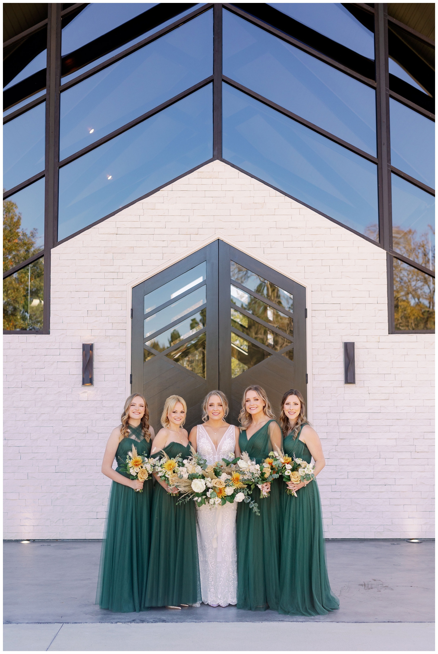 bride and bridesmaids in green emerald dresses standing in front of Jennings Trace Wedding venue in Montgomery, Texas