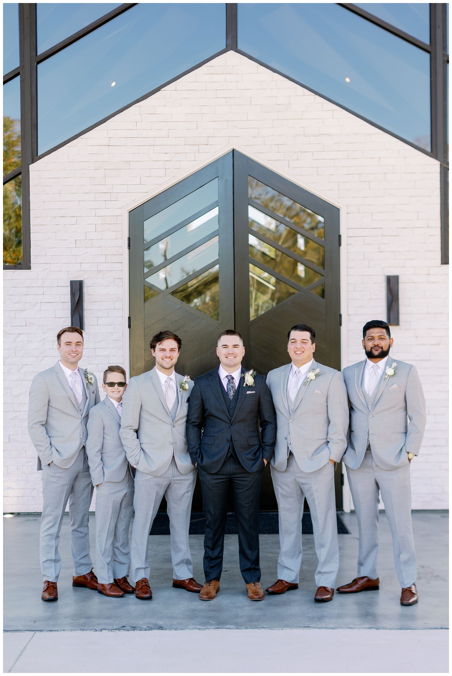 groomsmen in gray suits with groom in navy suit