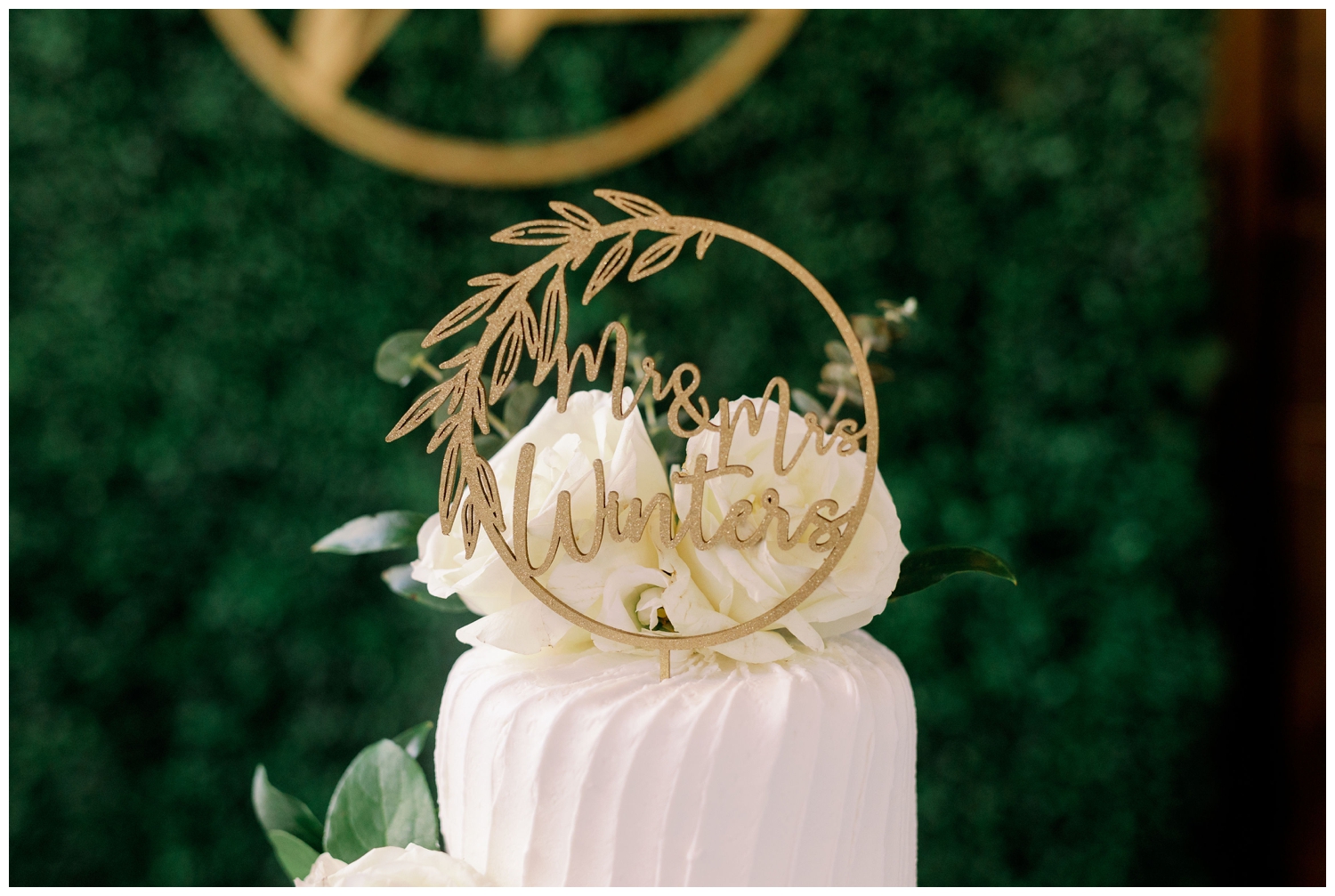 white cake with gold monogrammed cake topper