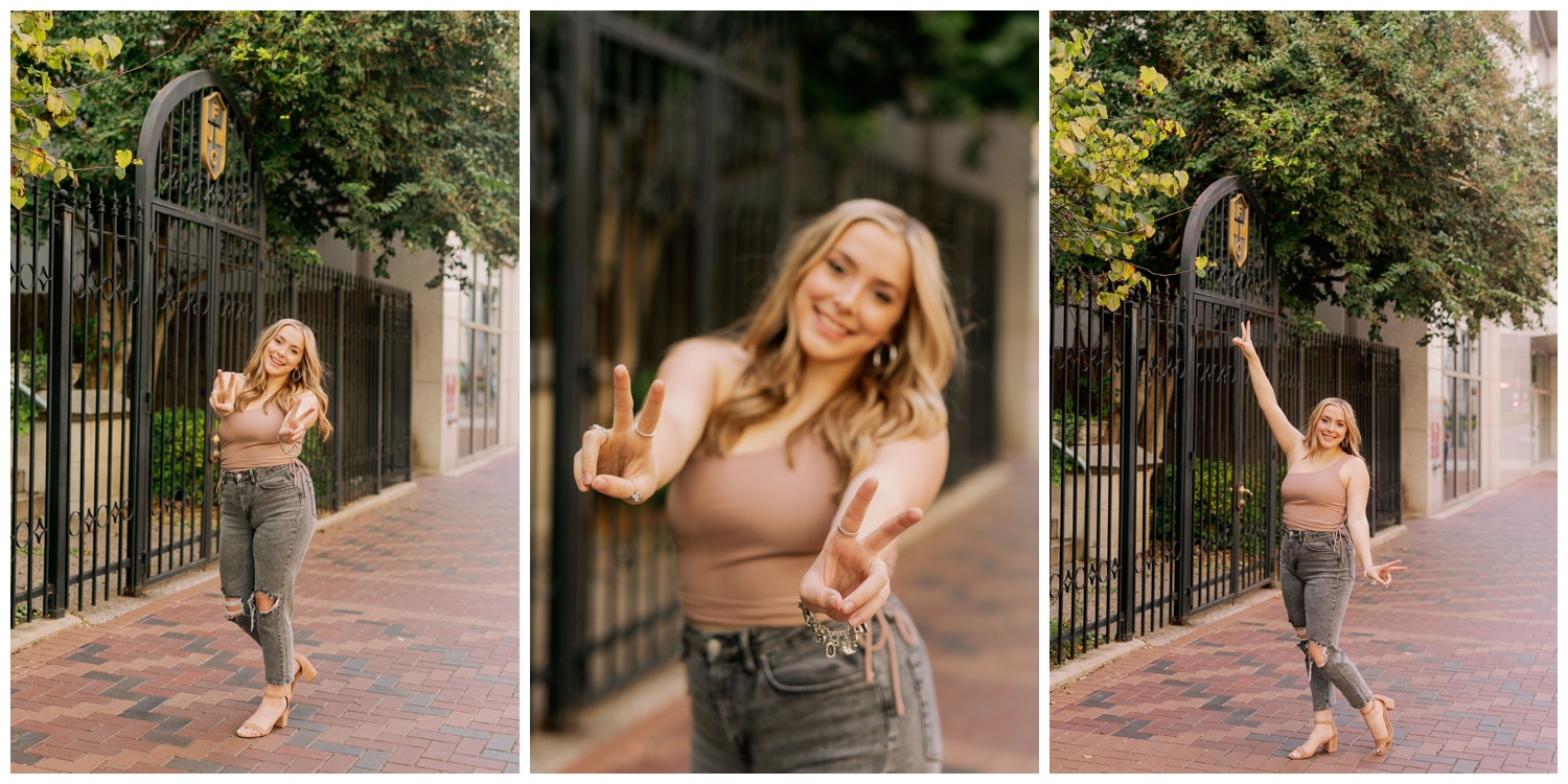 high school senior in jeans and beige tank shirt holding out peace sign with hands senior photos Main Street Houston
