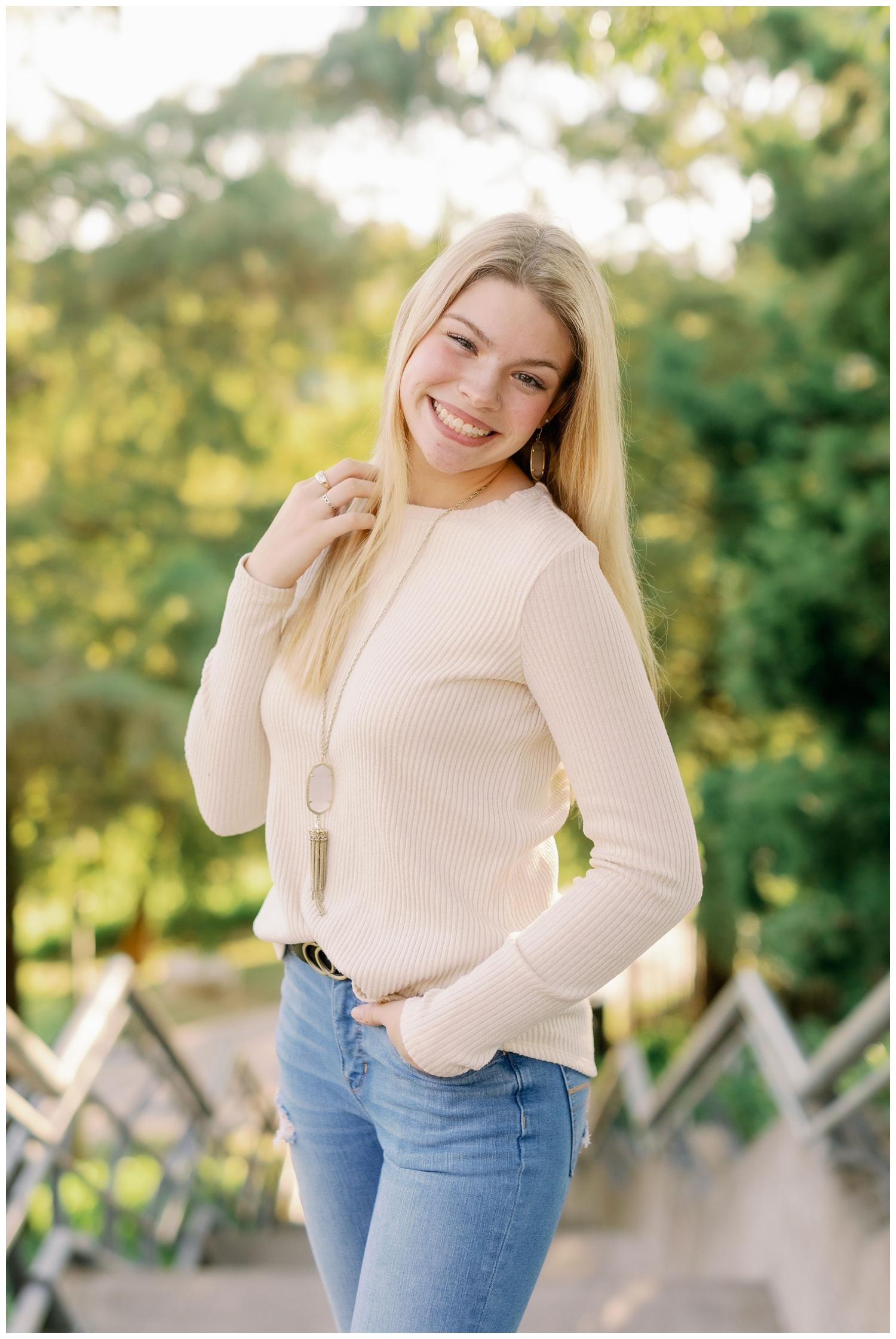 girl in jeans and cream sweater smiling Senior Pictures South Boulevard