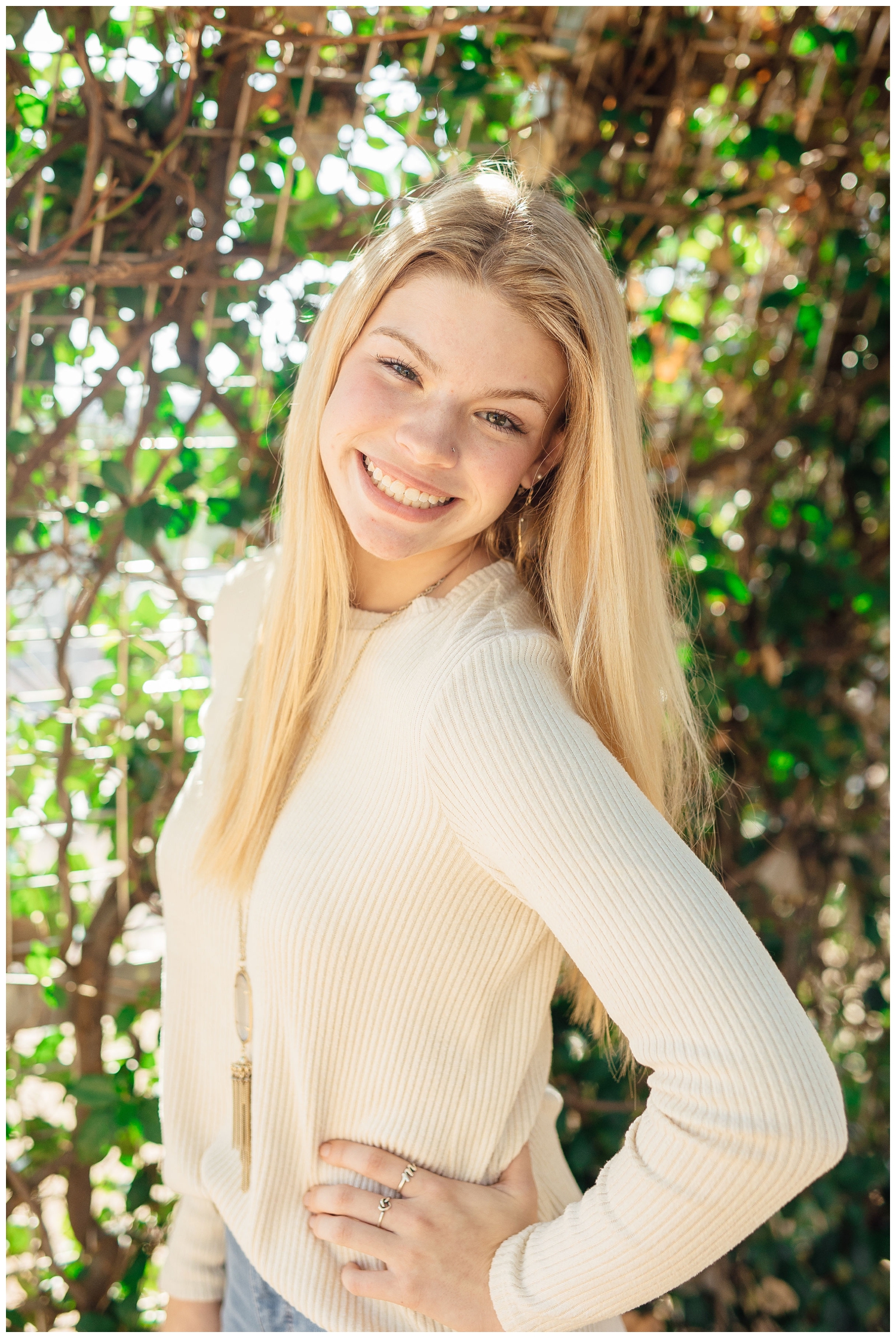 girl in cream sweater smiling at camera for Reed Gallagher Photography