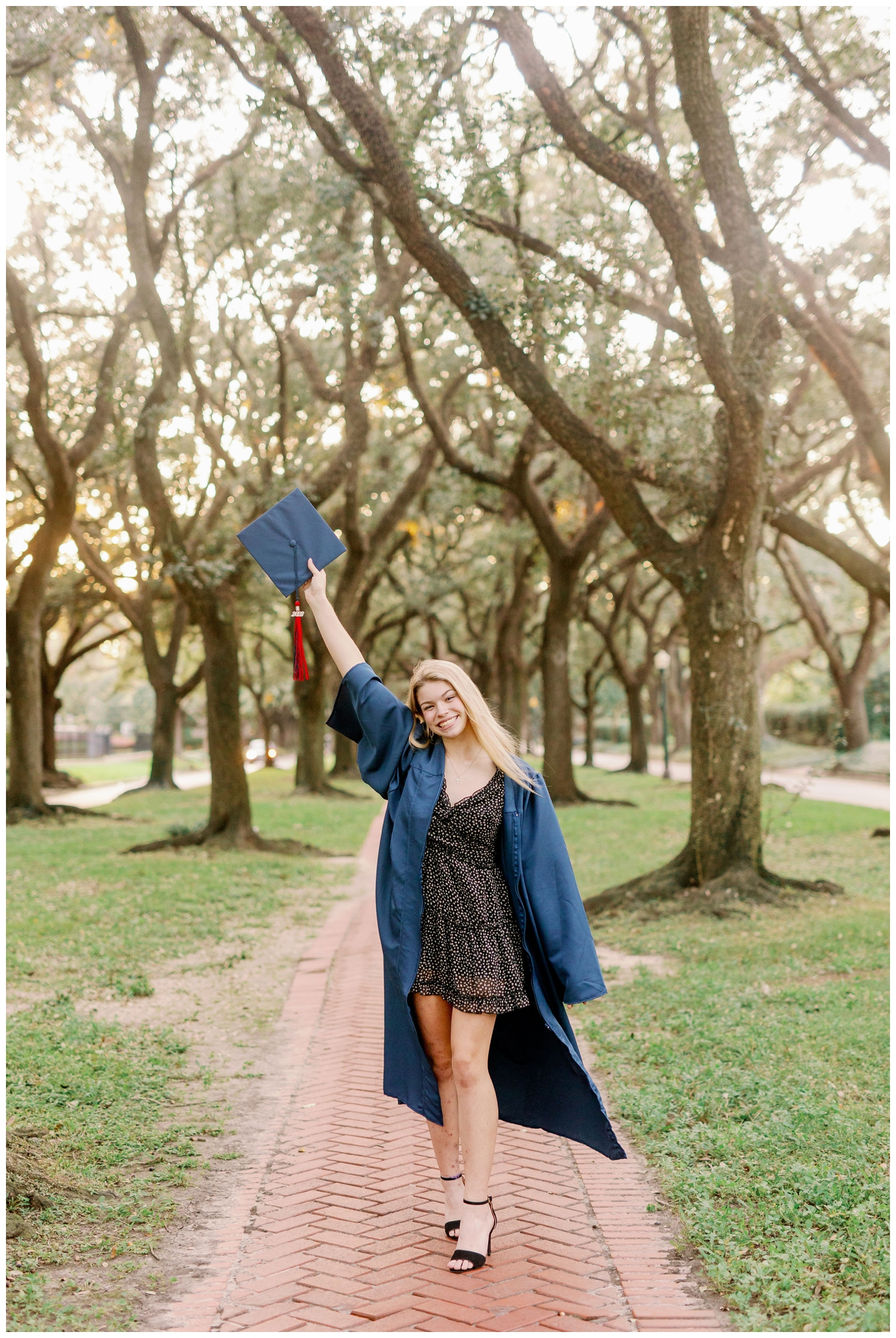 girl in navy graduation gown holding cap in air Senior Pictures South Boulevard