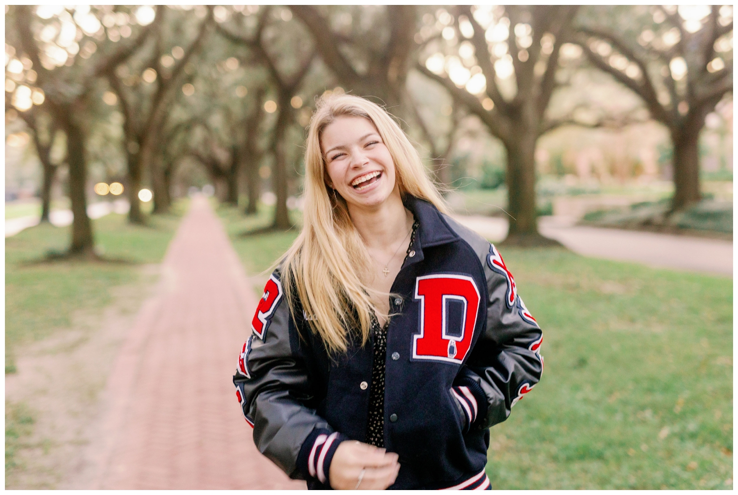 Senior Pictures South Boulevard with girl laughing wearing letter jacket