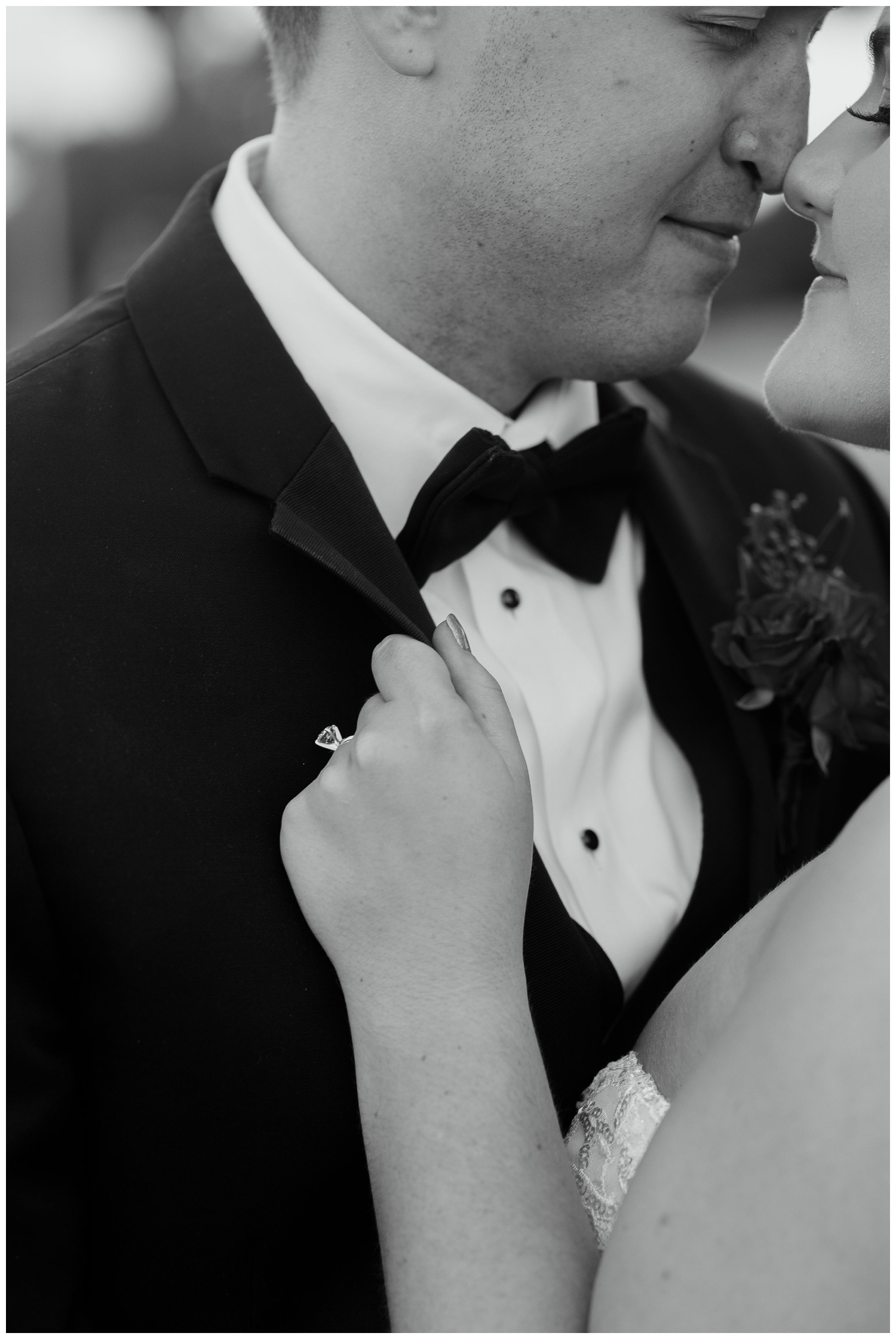 black and white portrait of bride's hand on groom's tux