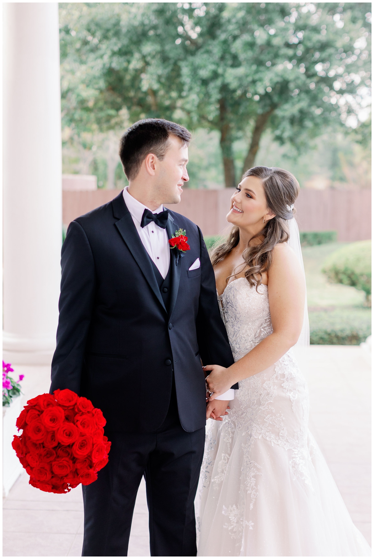bride and groom couple portrait outside with red roses in Sugar Land, Texas