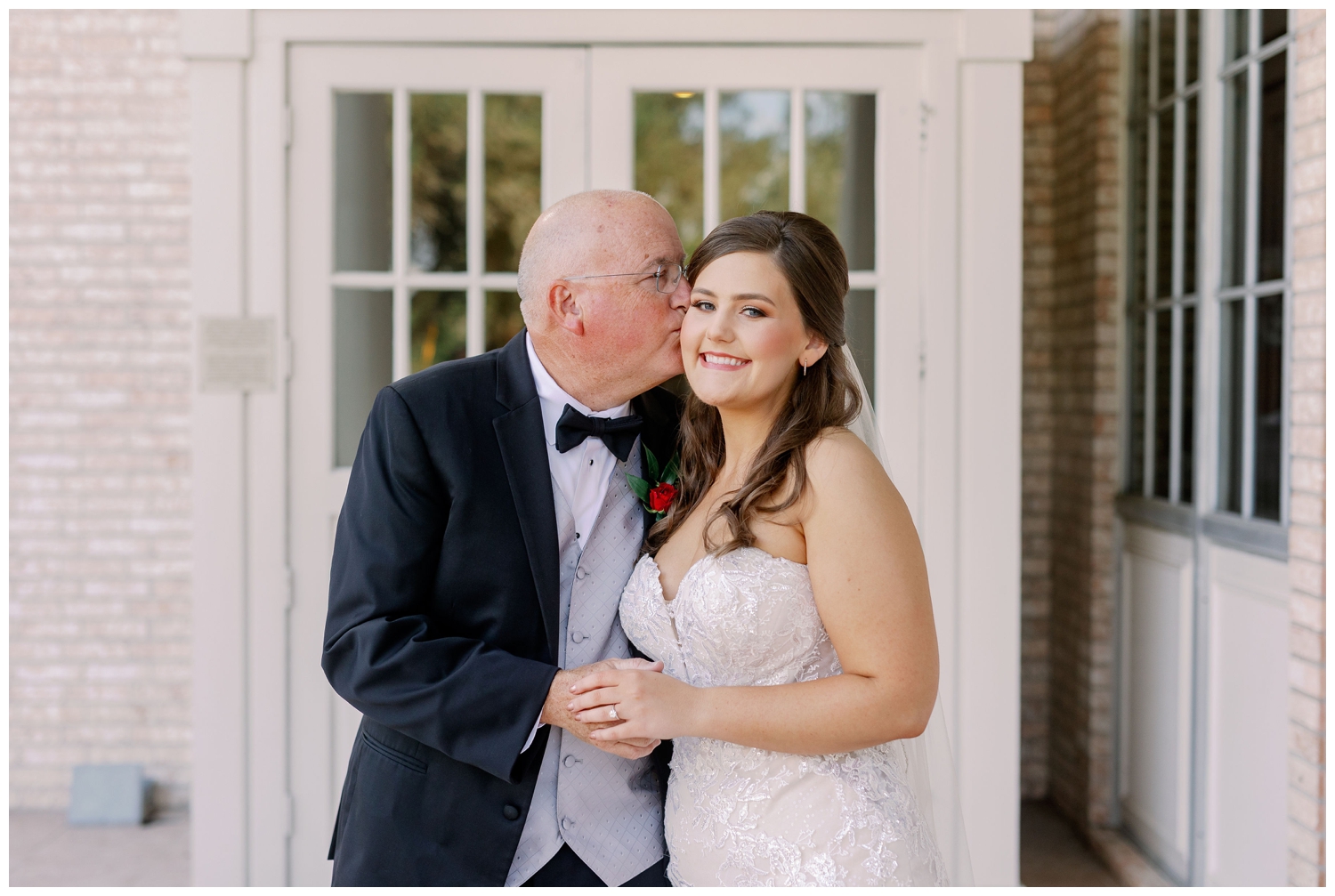father of the bride kissing his daughter on her wedding day in Sugar Land, Texas