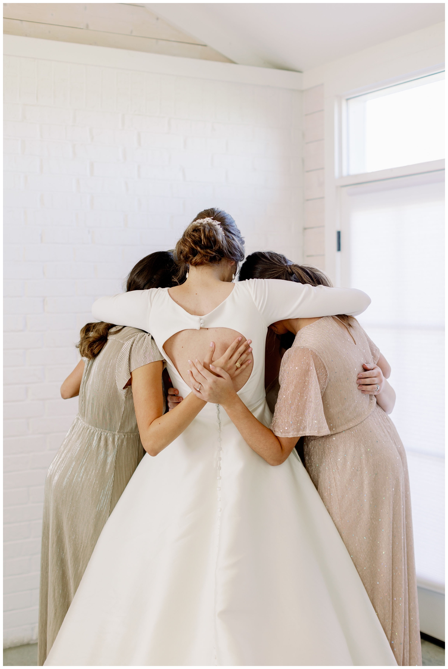bride hugging bridesmaids for College Station wedding photography inside Gin at Hidalgo Falls