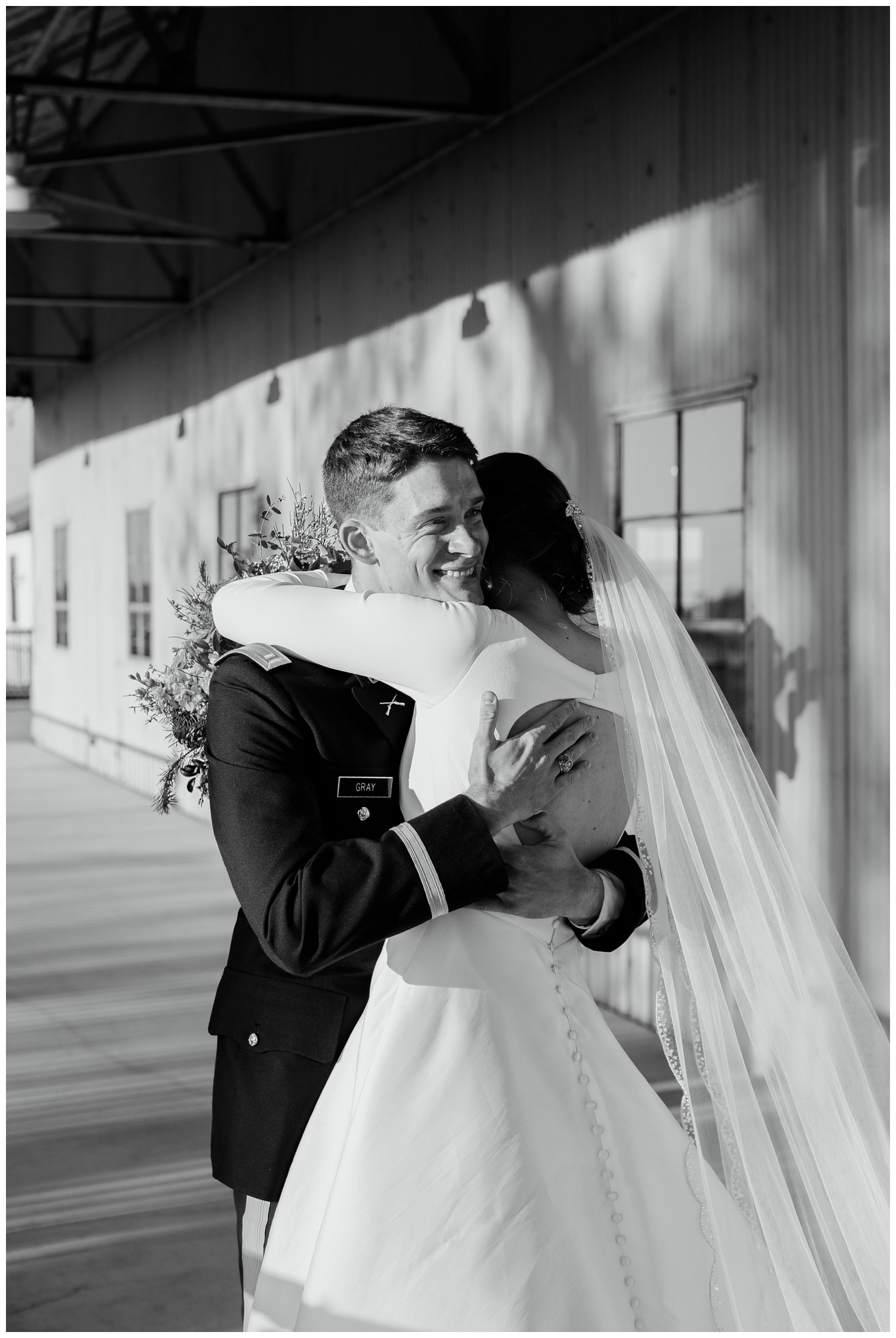 black and white image of bride and groom hugging
