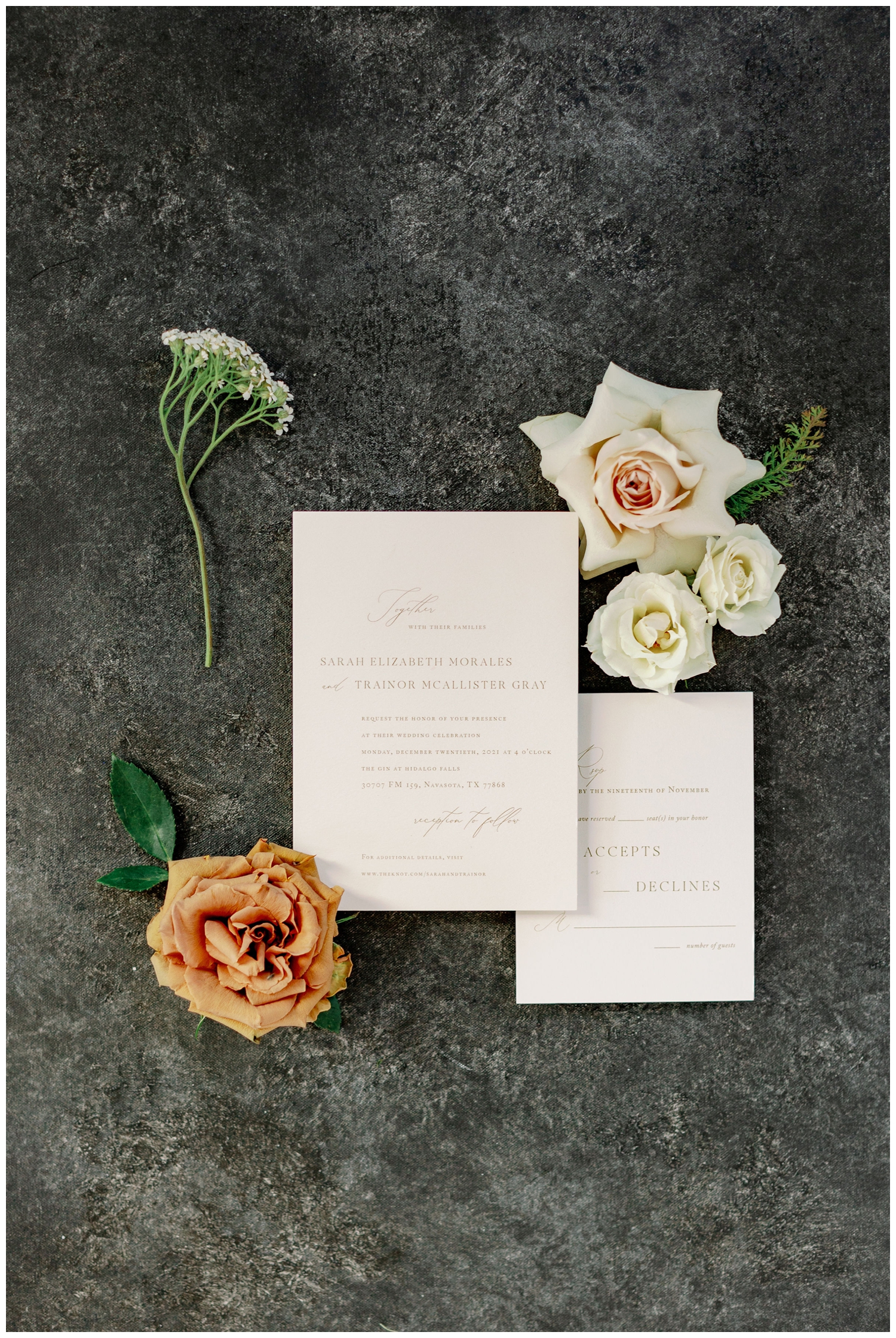 white wedding invitation suite surrounded by white and blush florals