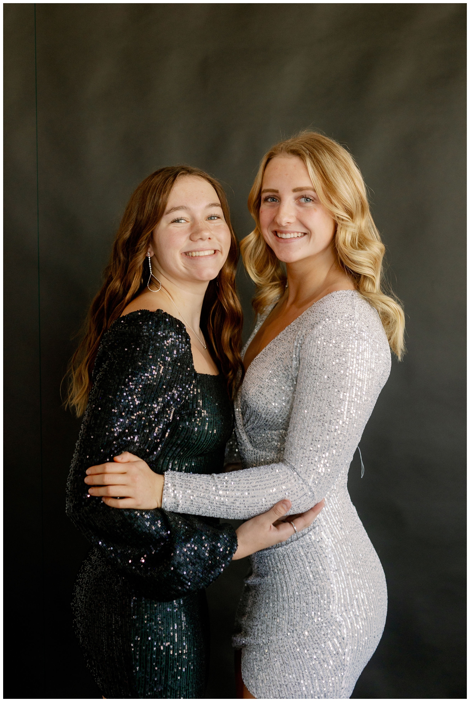 high school senior girls in black and silver dresses standing and hugging New Years senior pictures