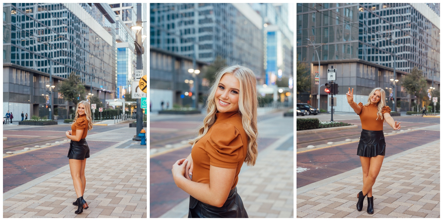 high school senior girl standing on Main Street smiling in downtown Houston