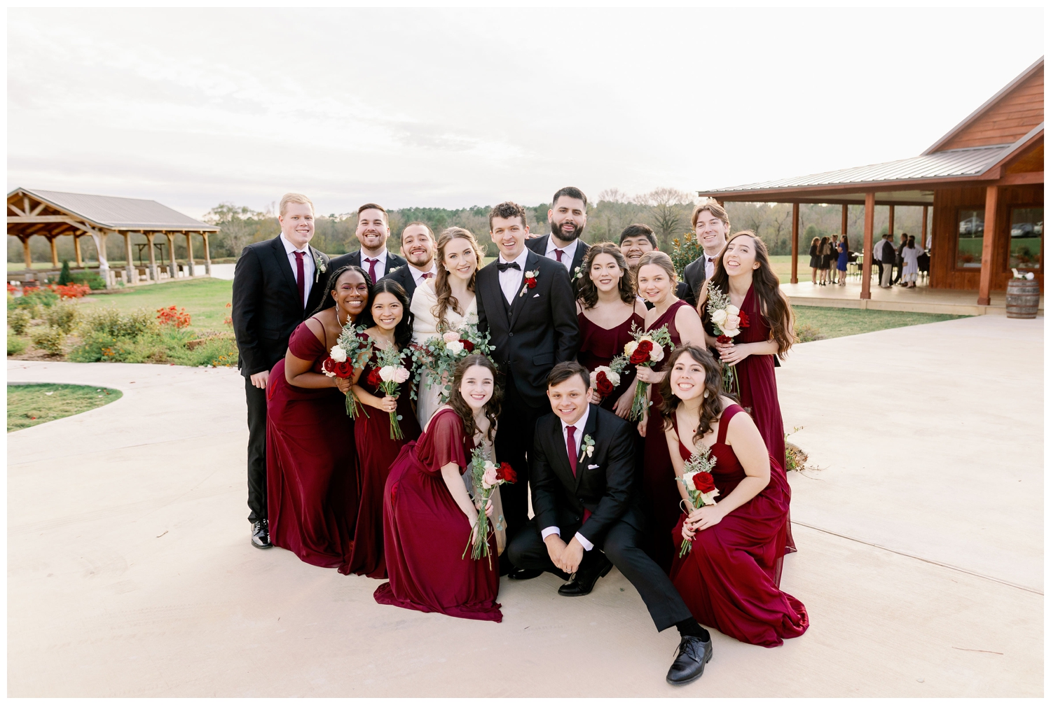 bridal party at Union Ranch in burgundy dresses and black tuxes