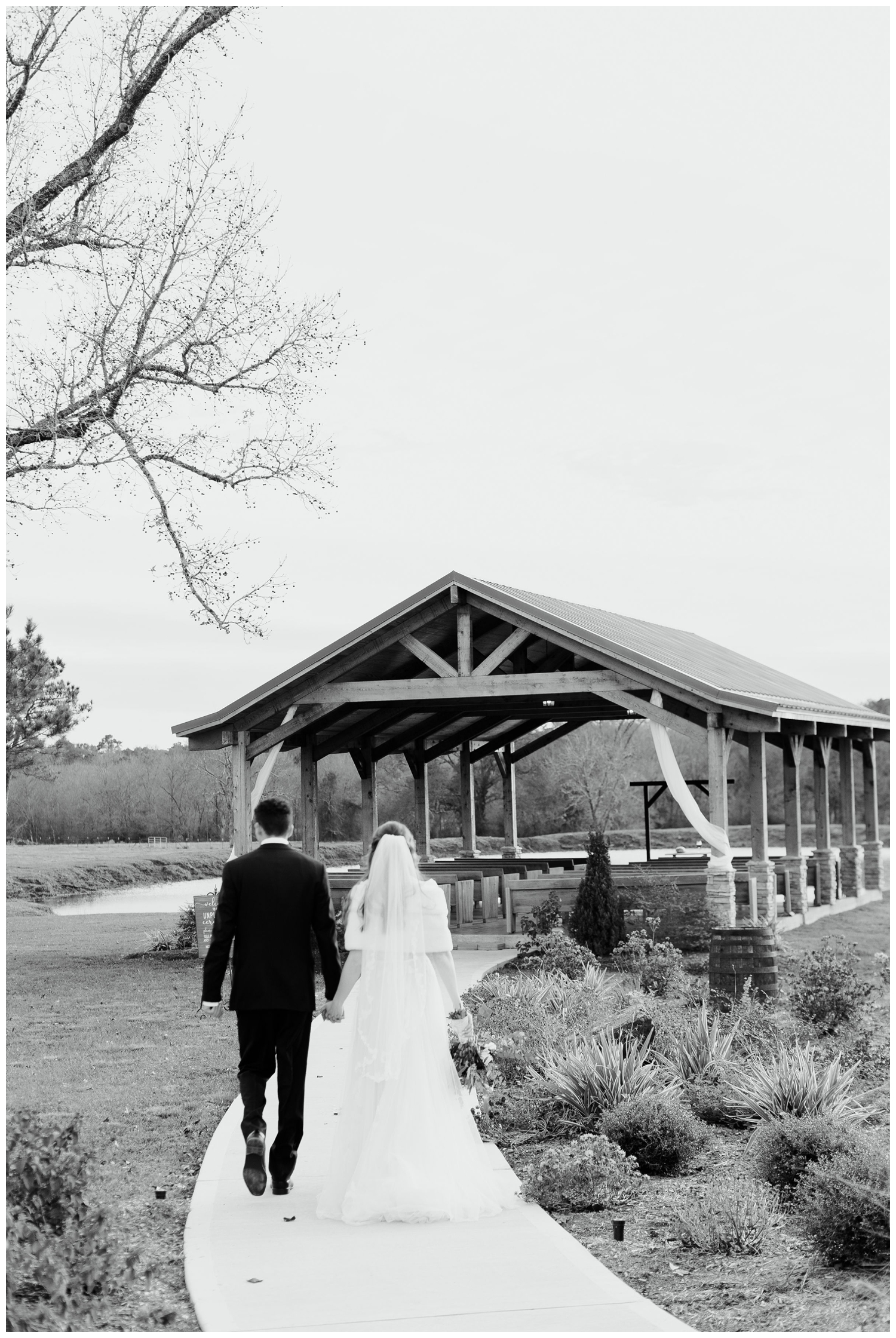 black and white image of bride and groom holding hands walking toward Union Ranch ceremony space