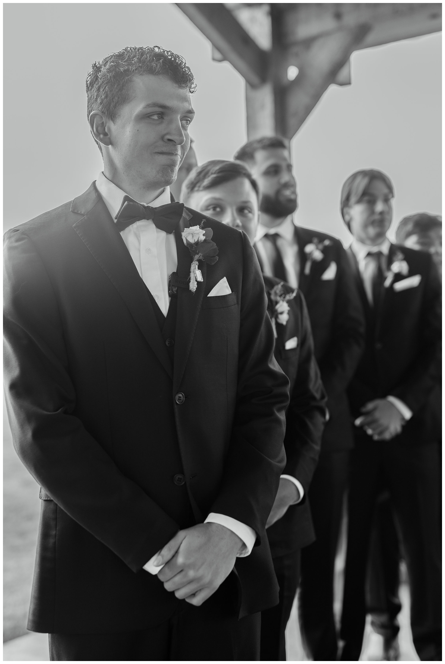 black and white image of groom smiling during winter Union Ranch Wedding ceremony