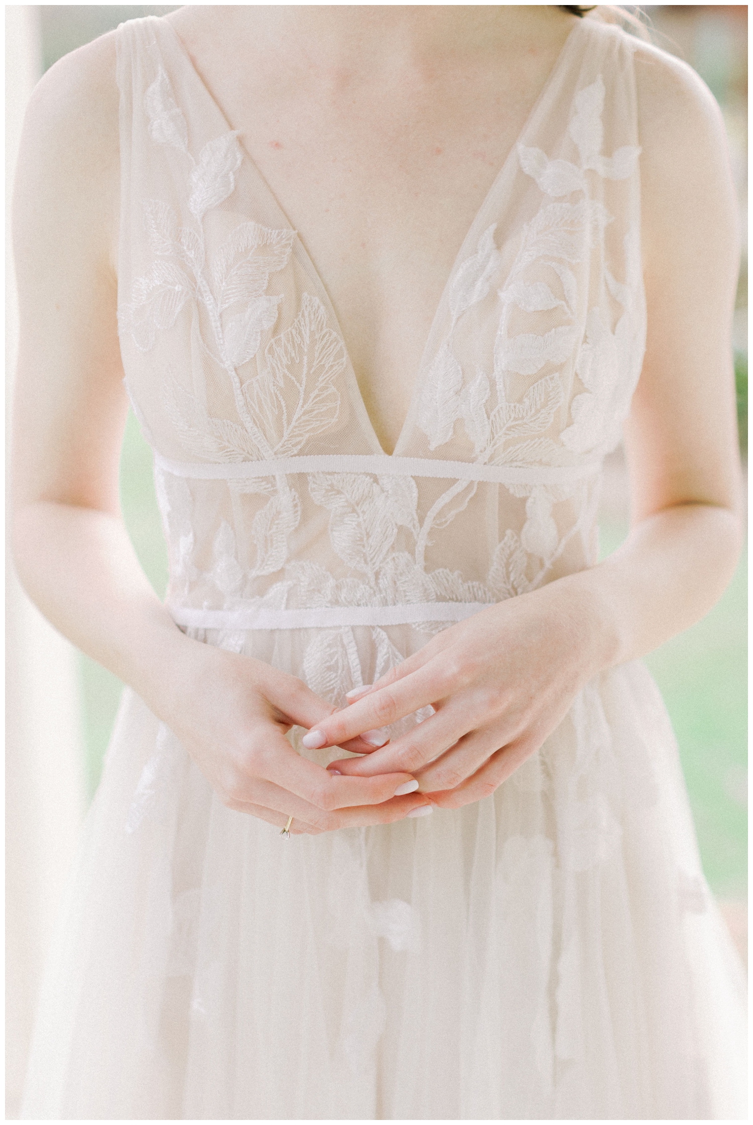 detail shot of bride's hands clasped in front of her waist