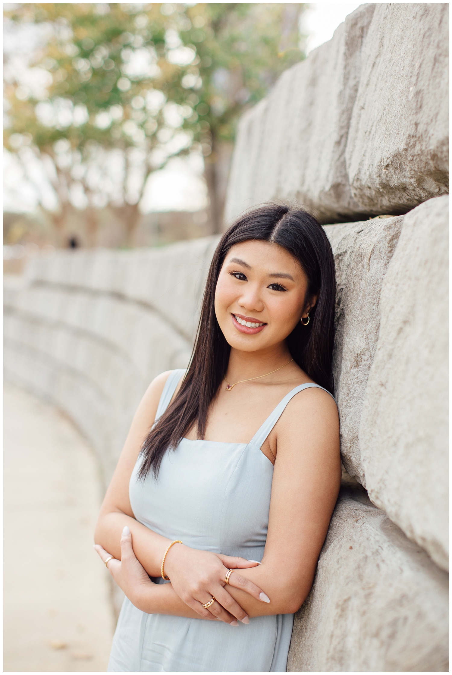 chic houston senior photos with girl in blue jumpsuit leaning on a gray wall