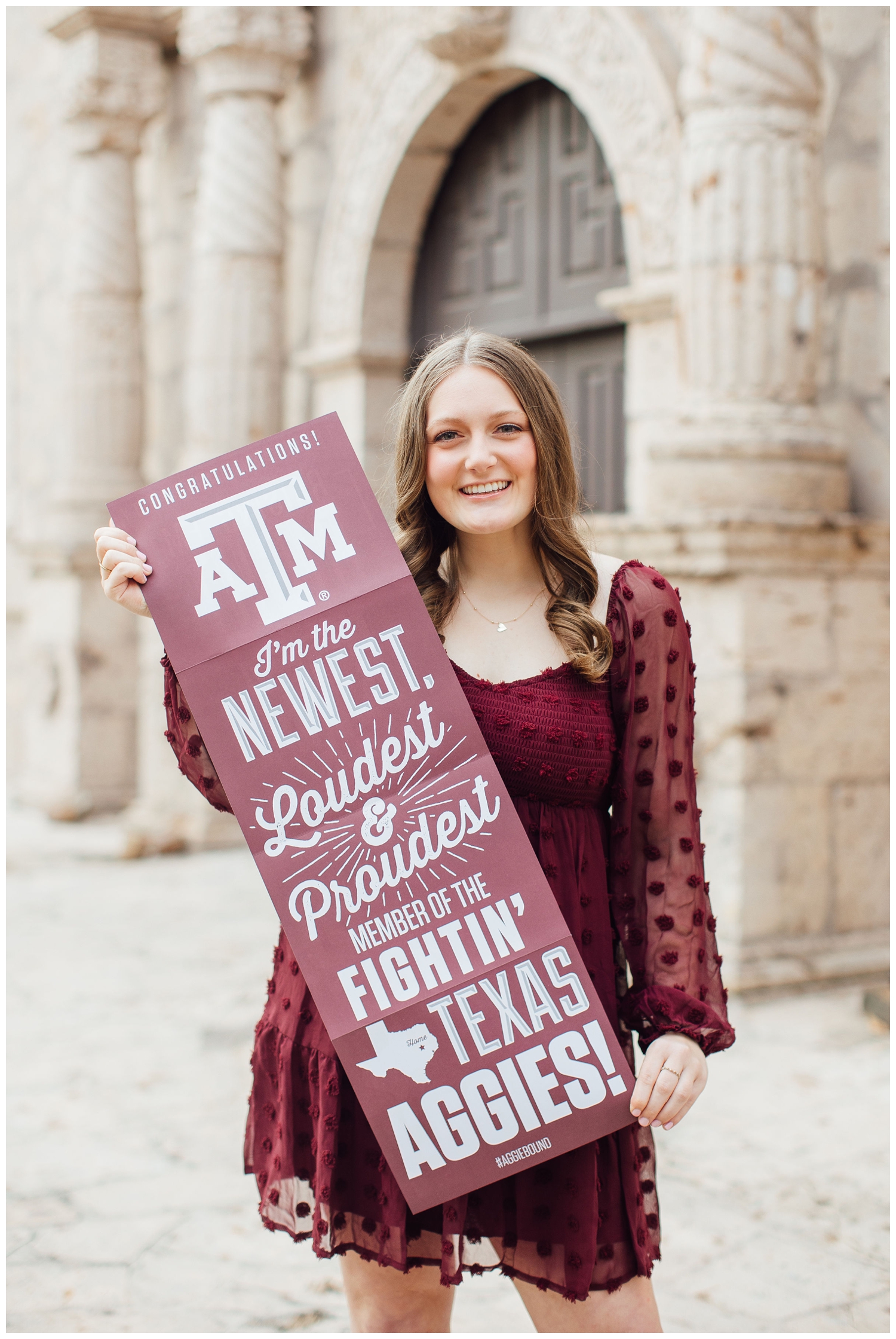 high school senior in maroon dress holding Aggie sign Cypress senior photographer at Cy-Hope