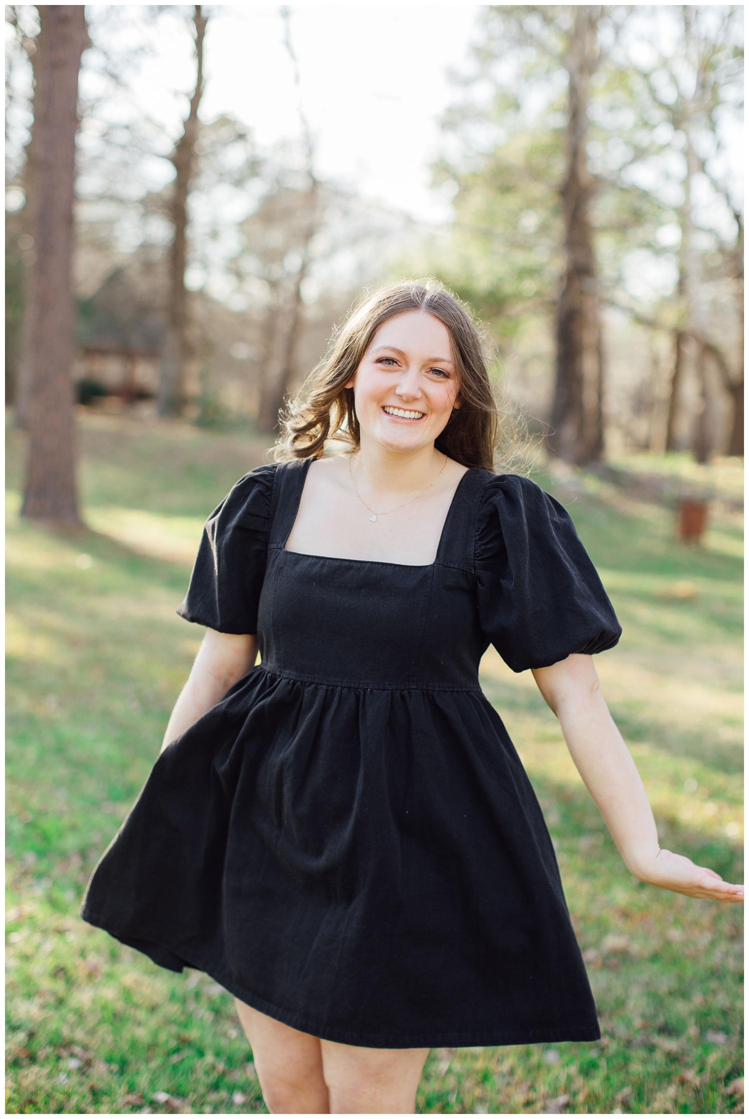 girl standing in field twirling in black dress