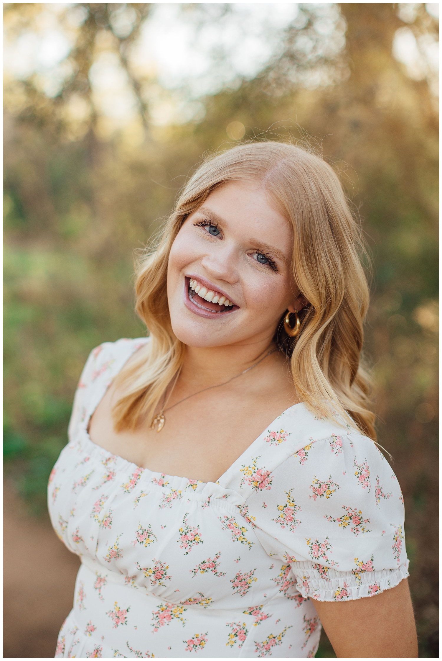 high school senior girl smiling in white sundress at Houston Arboretum