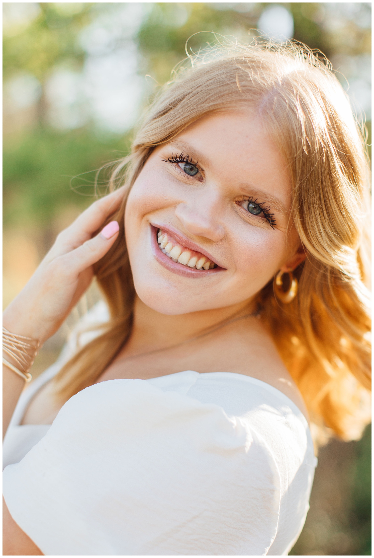 high school senior girl smiling with hand in hair Houston Arboretum Houston Senior Portrait Photographer