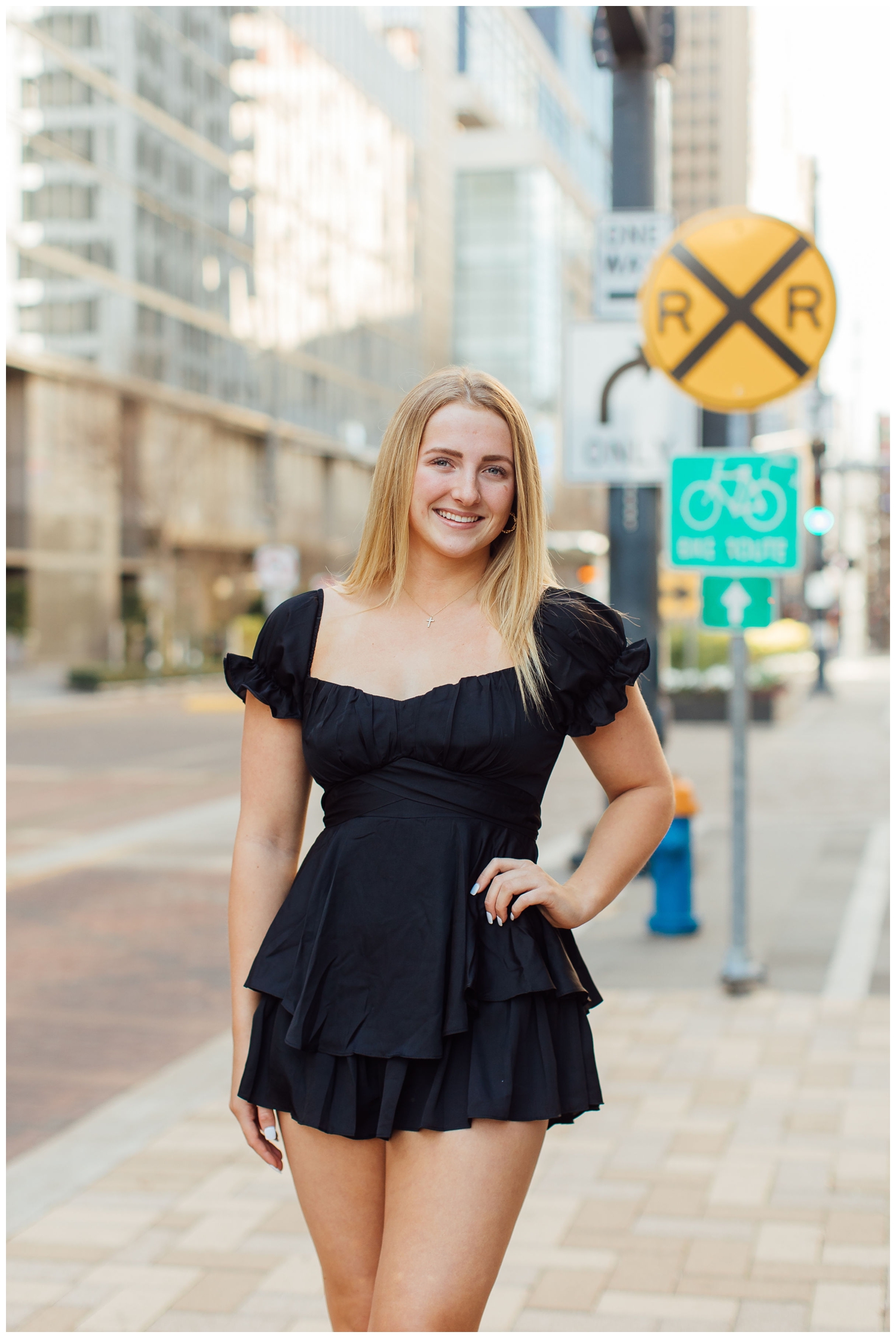 Urban senior photos Houston Main Street with girl in black dress hands on hips