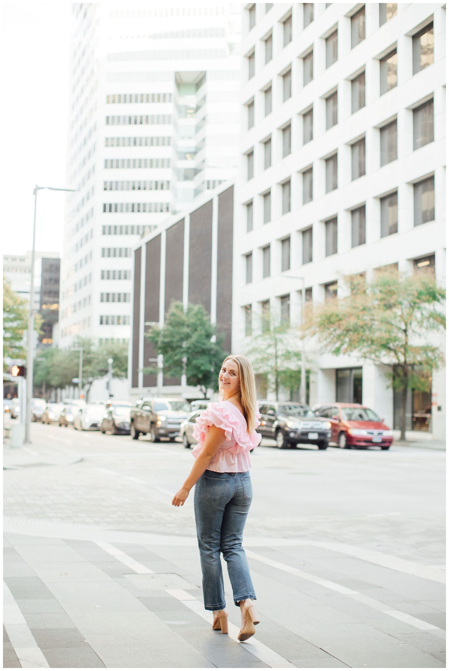 senior girl walking across Main Street downtown Houston