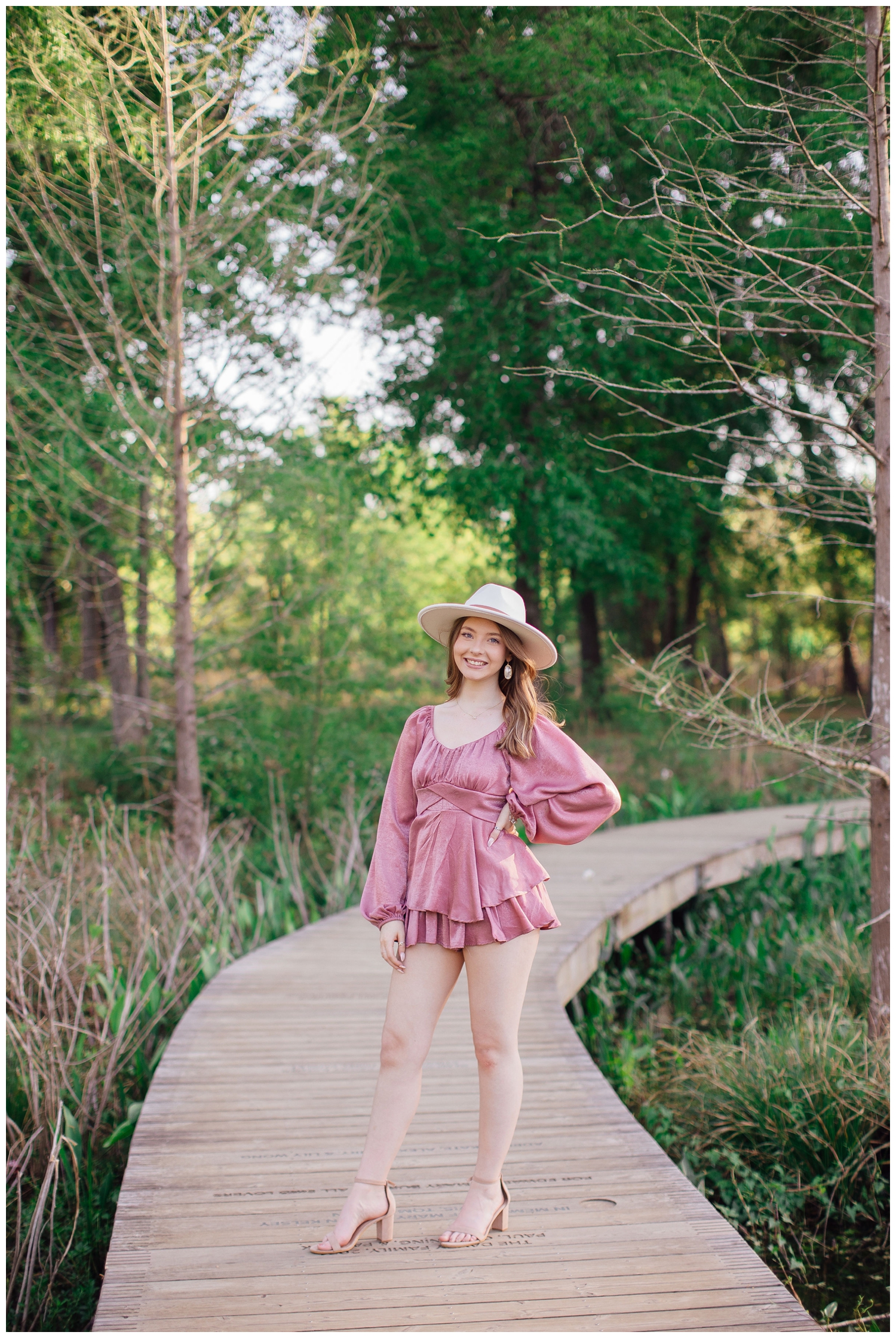 Houston girl with hand on hat for senior portraits Arboretum