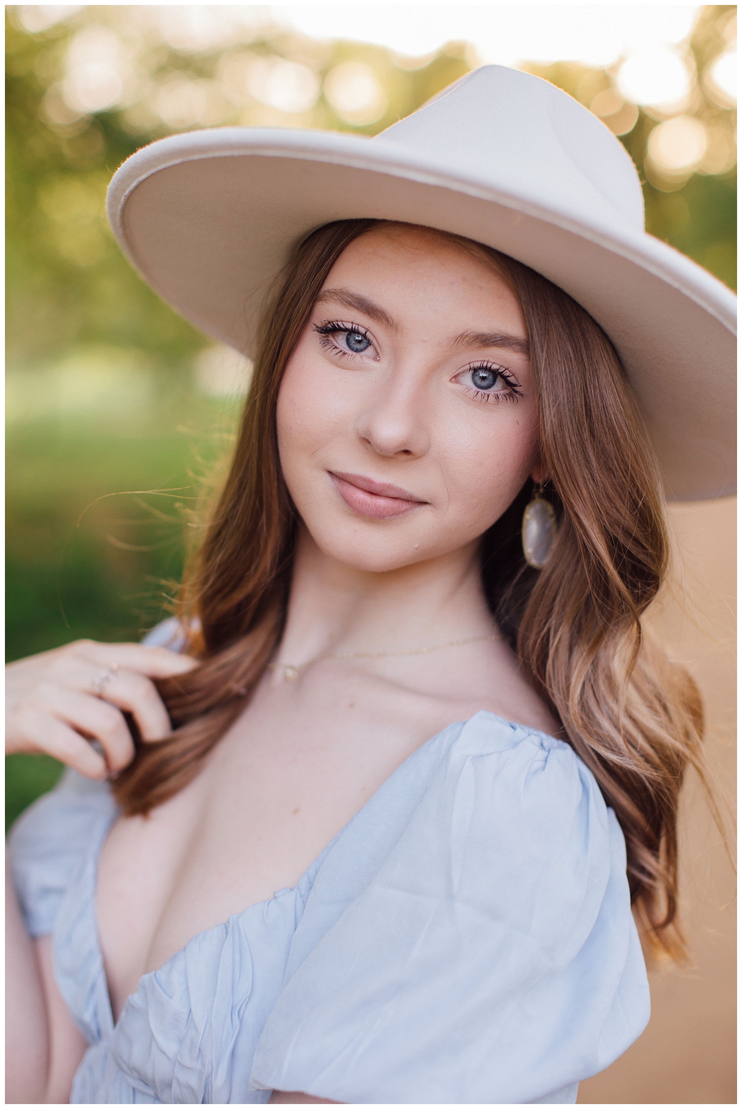 girl in light blue sundress wearing white hat