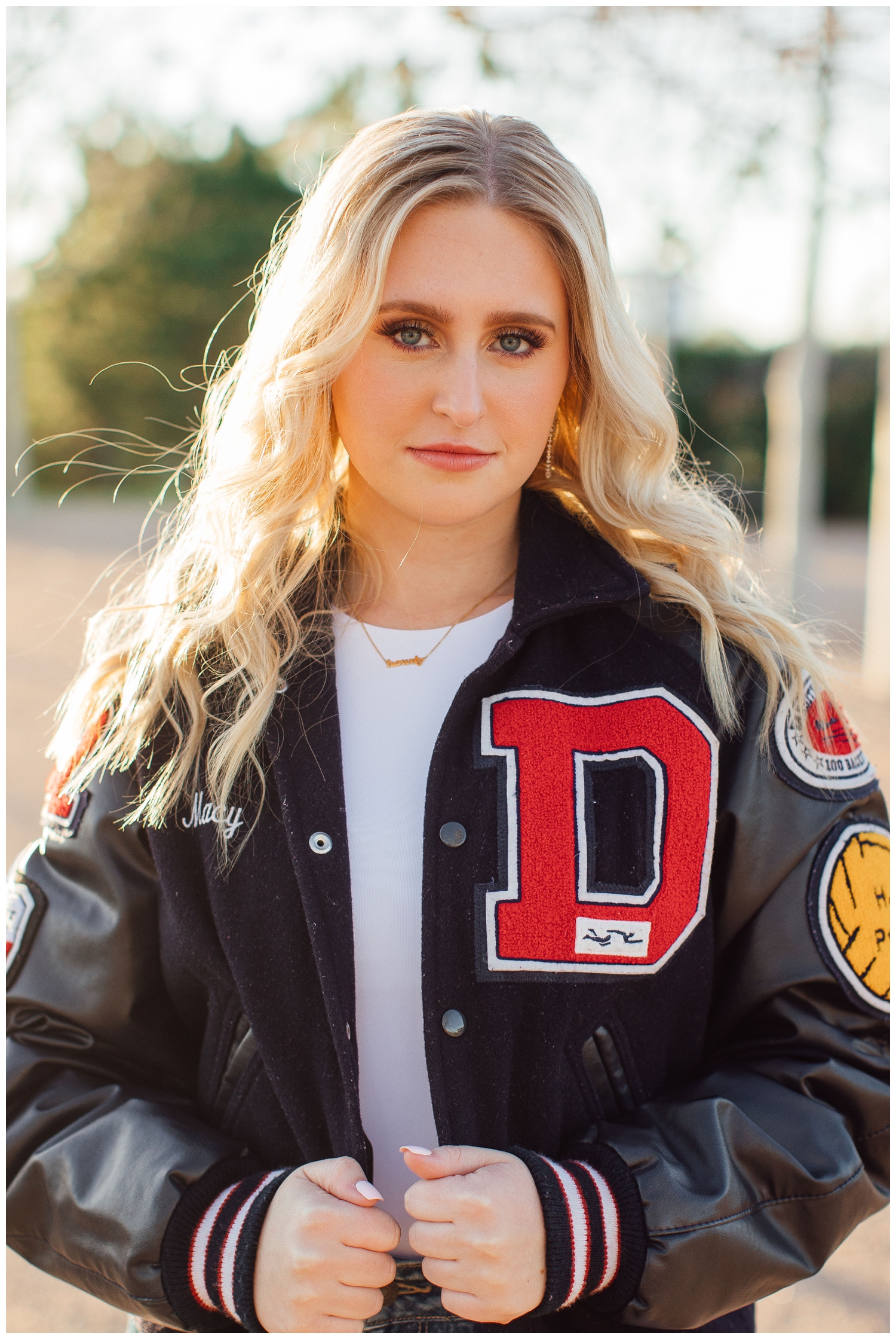 girl in letter jacket looking at camera for senior pictures Houston Texas