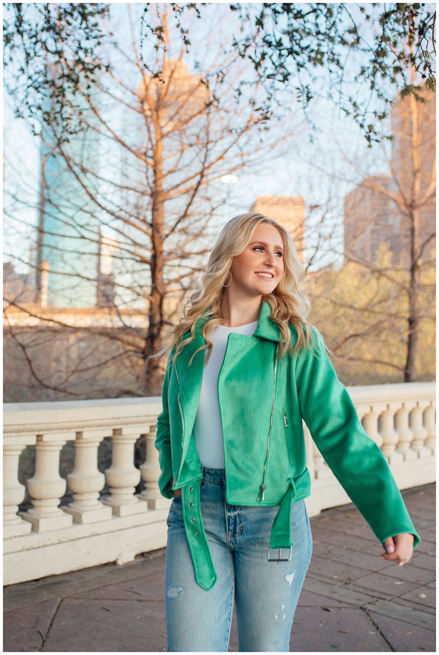 senior pictures Houston Texas on Sabine Street bridge in green jacket and jeans walking