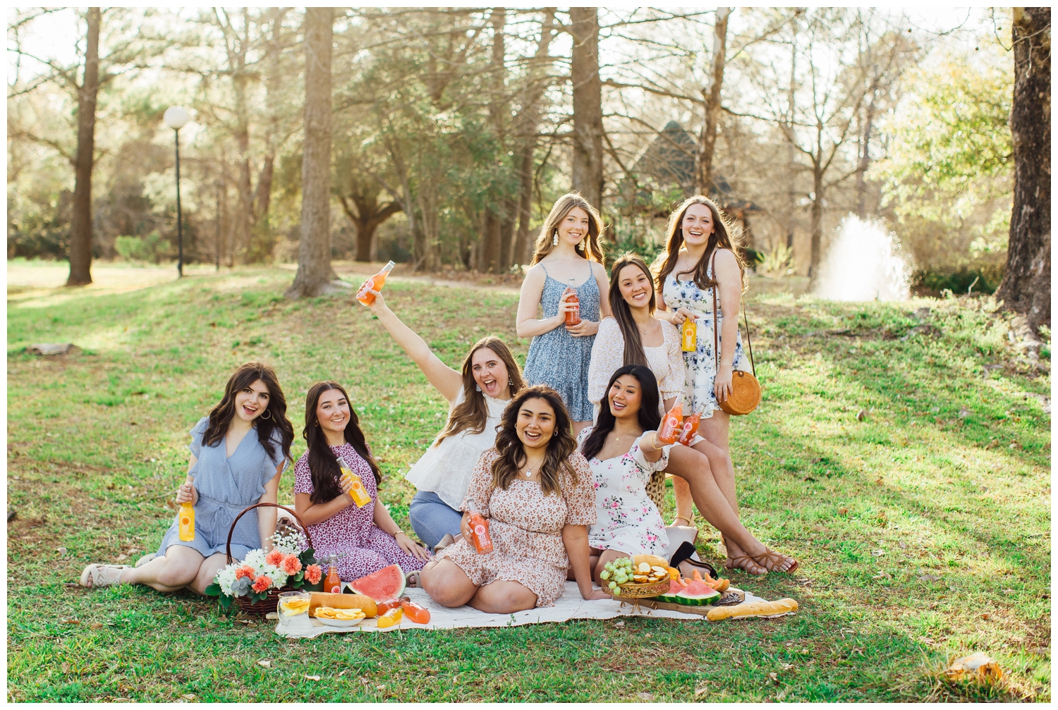 group of high school senior girls sitting on blanket outdoors for spring picnic senior pictures