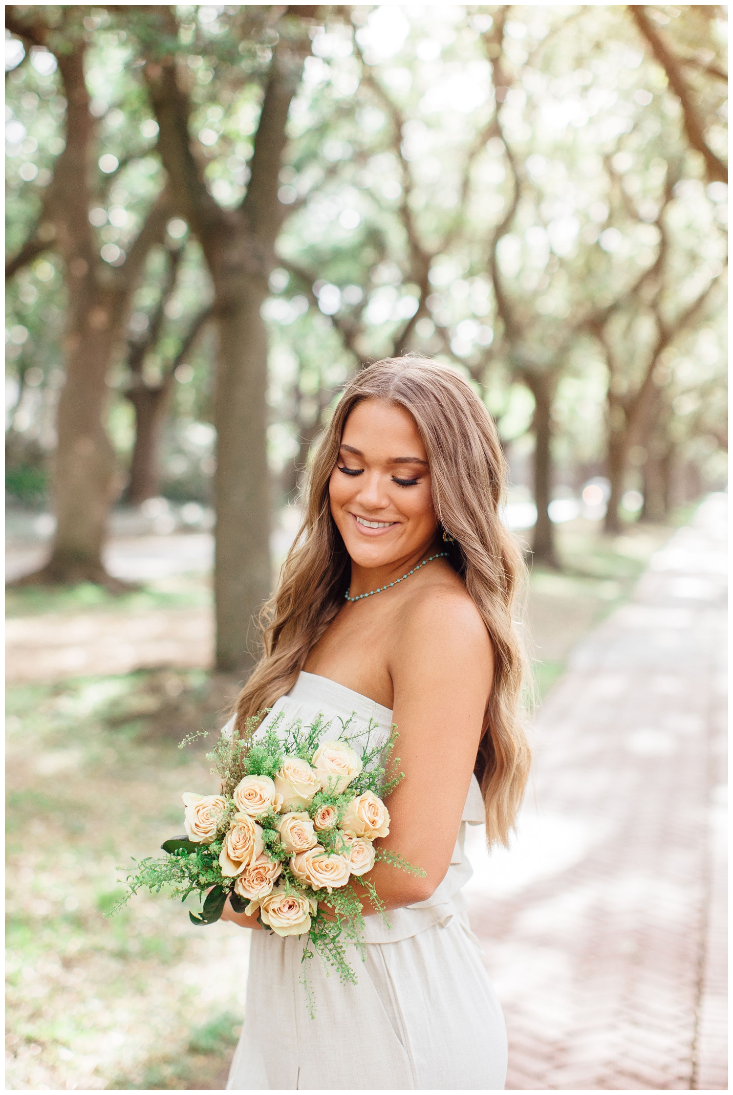 high school senior girl holding floral bouquet outdoor tree line Houston
