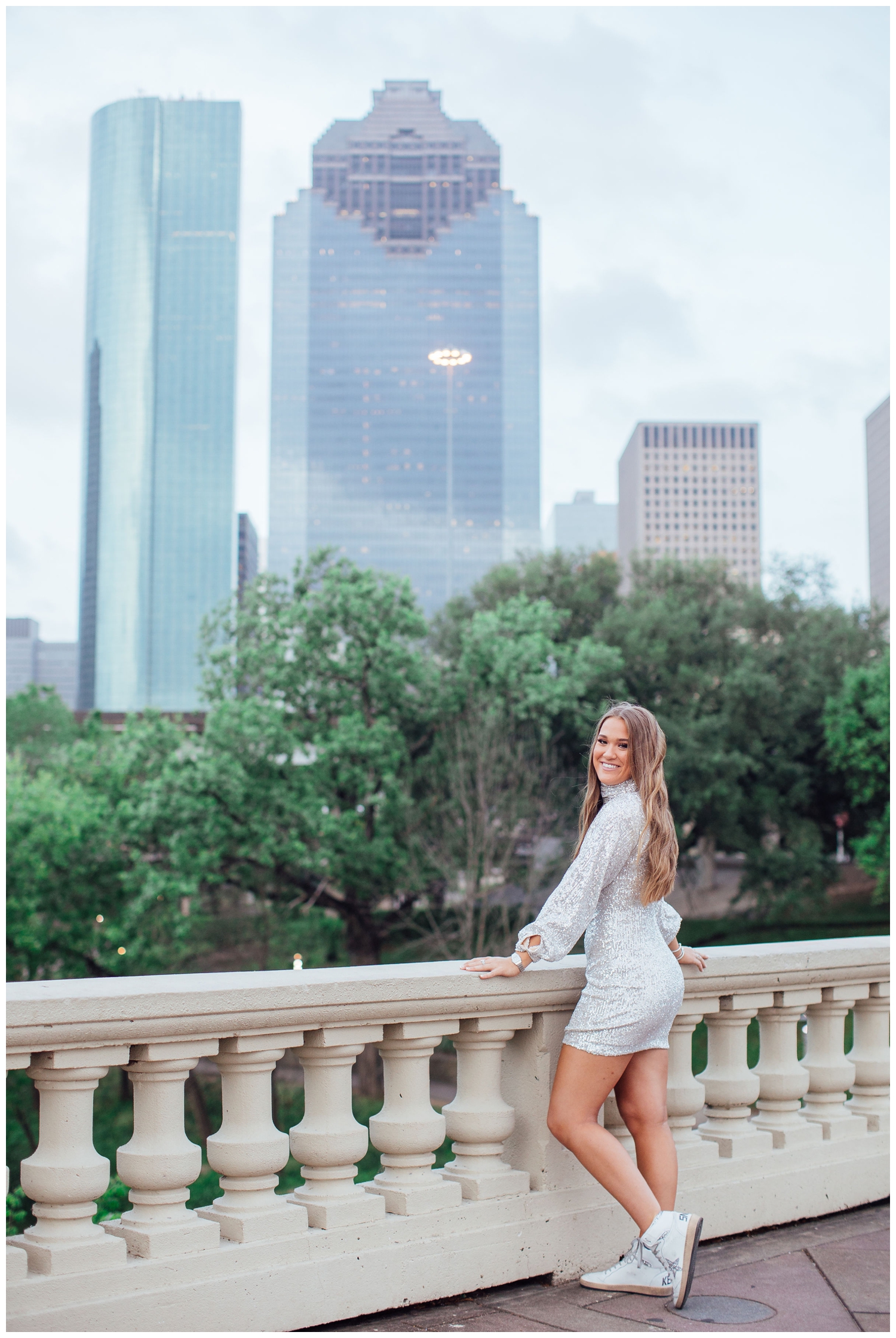 Houston skyline Sabine bridge with high school senior girl in sequence dress smiling over shoulder