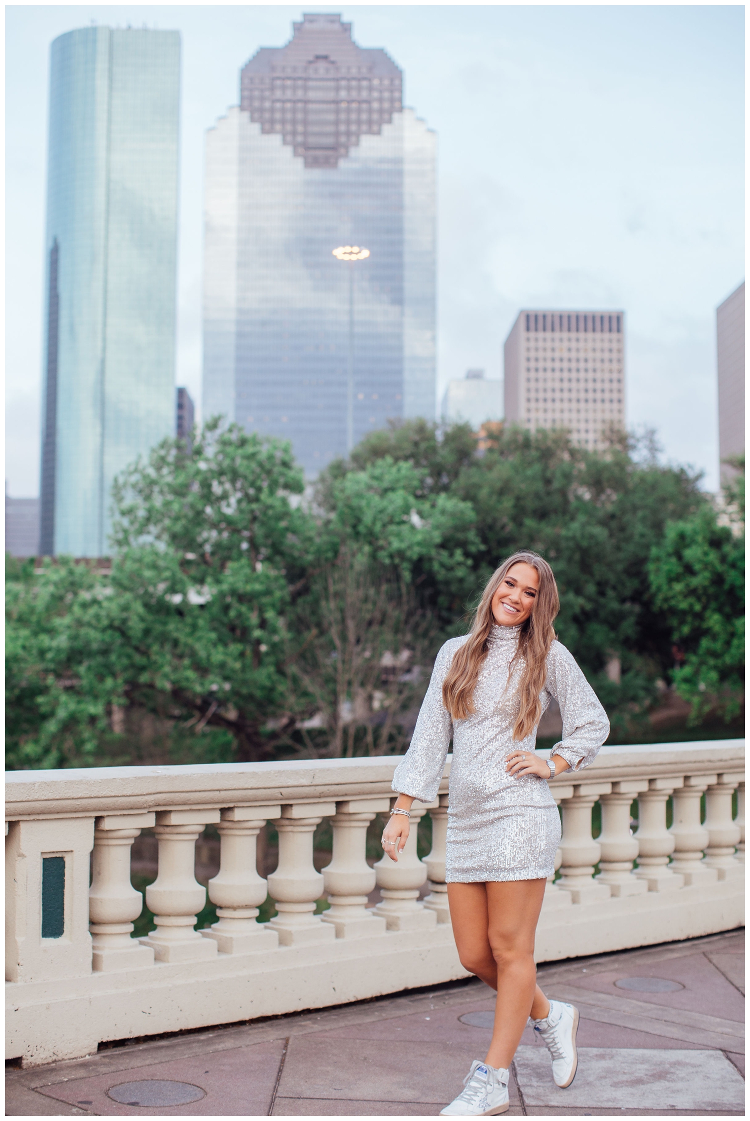 vibrant senior pictures in Houston with girl in silver sequence dress on Sabine Bridge